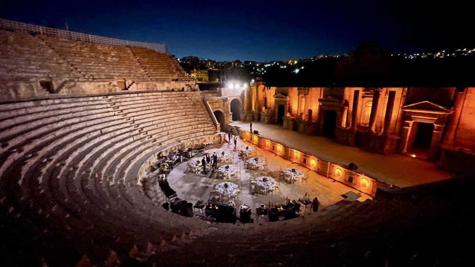 Private event set up with tables and chairs in the center of an amphitheater in Jerash