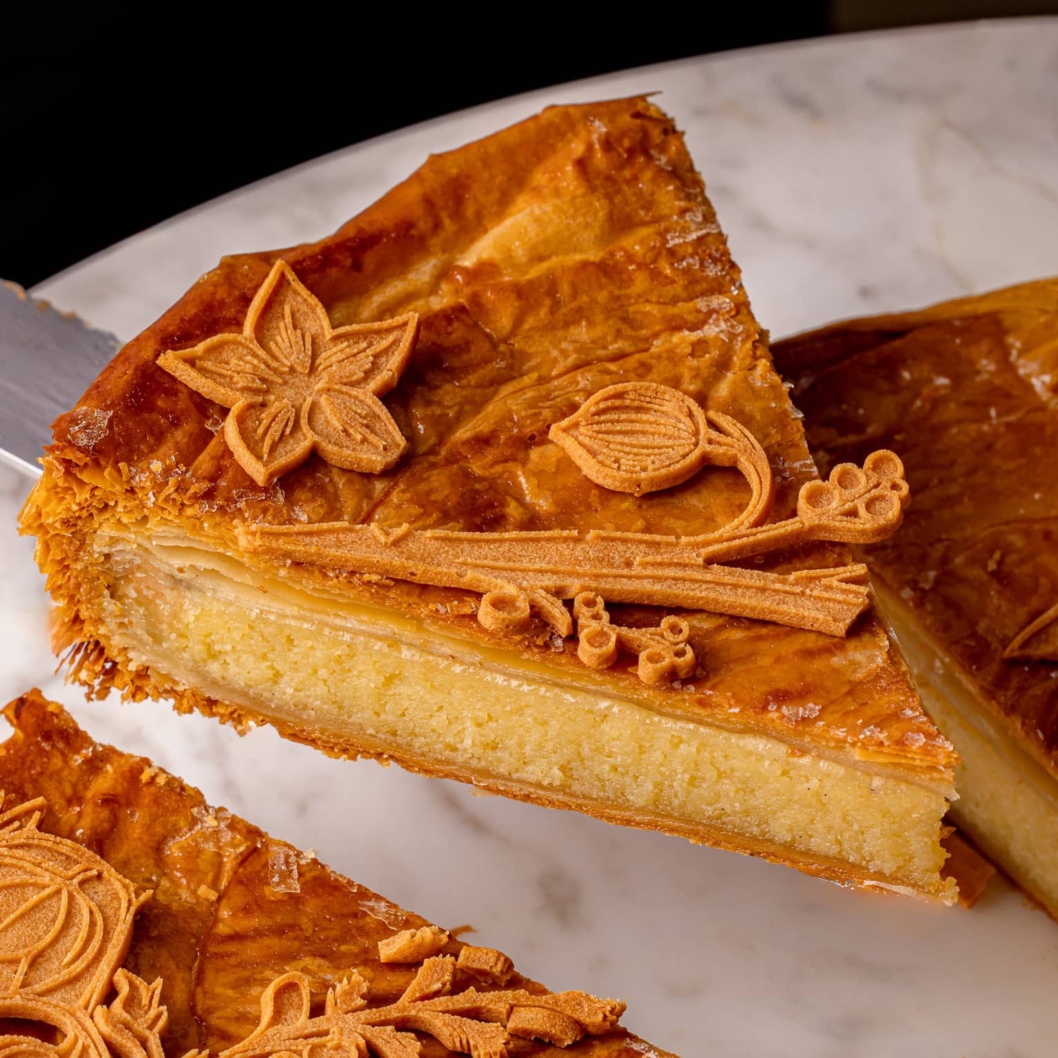 A slice of a flaky pastry with floral details