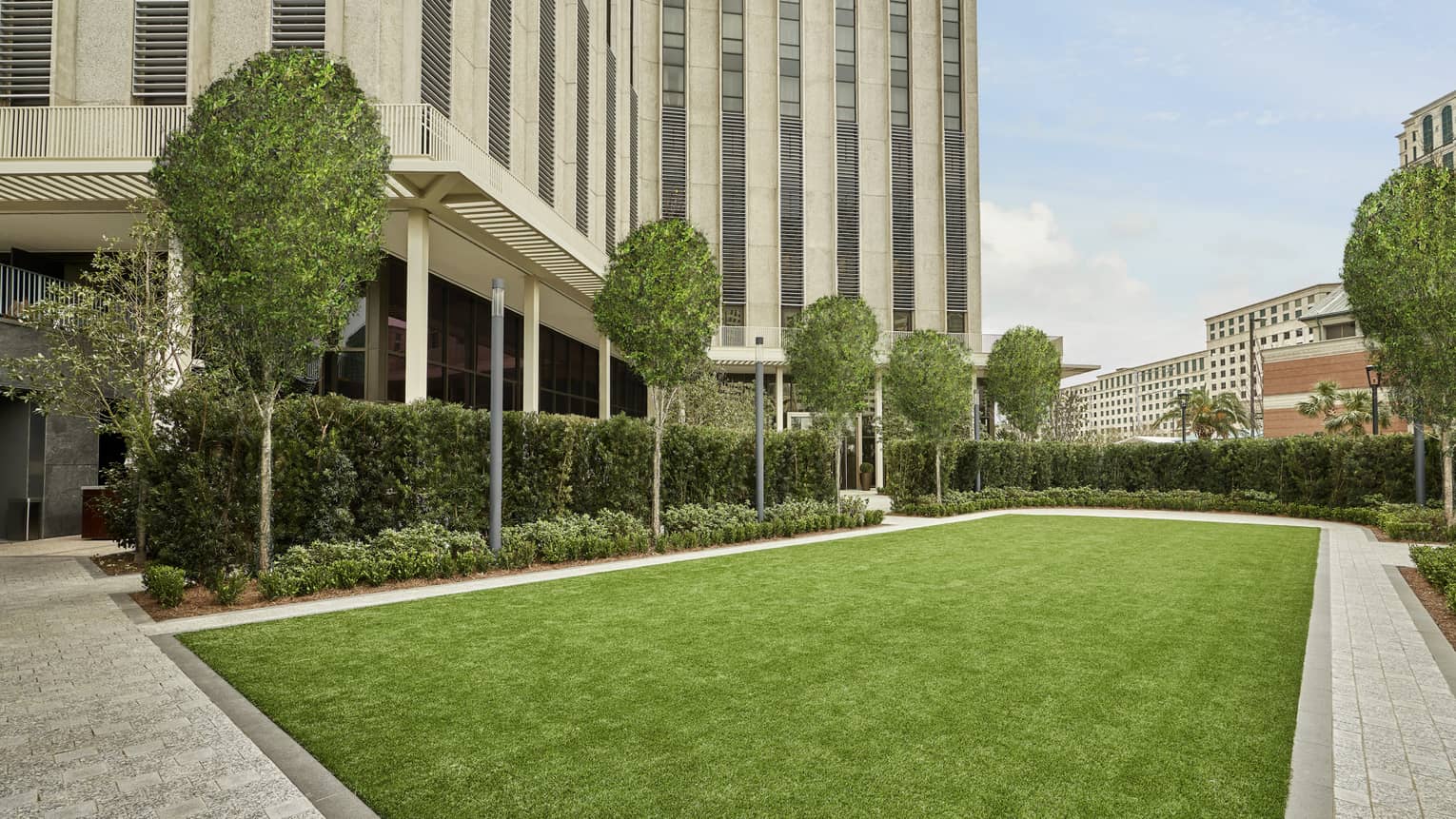 An outdoor area with a lawn of green grass and trees.