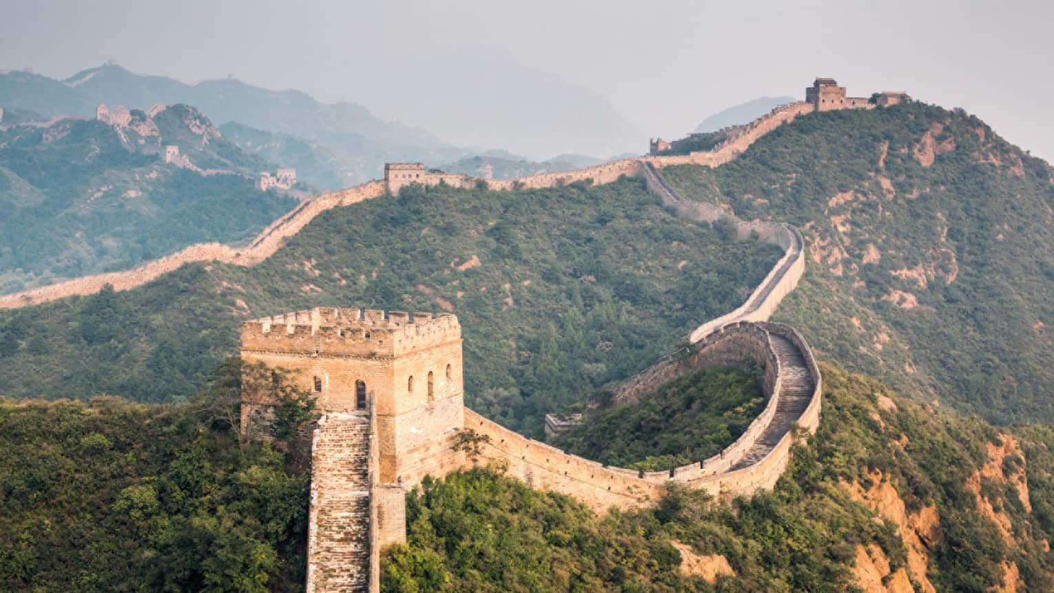 Great Wall of China winding along green mountain