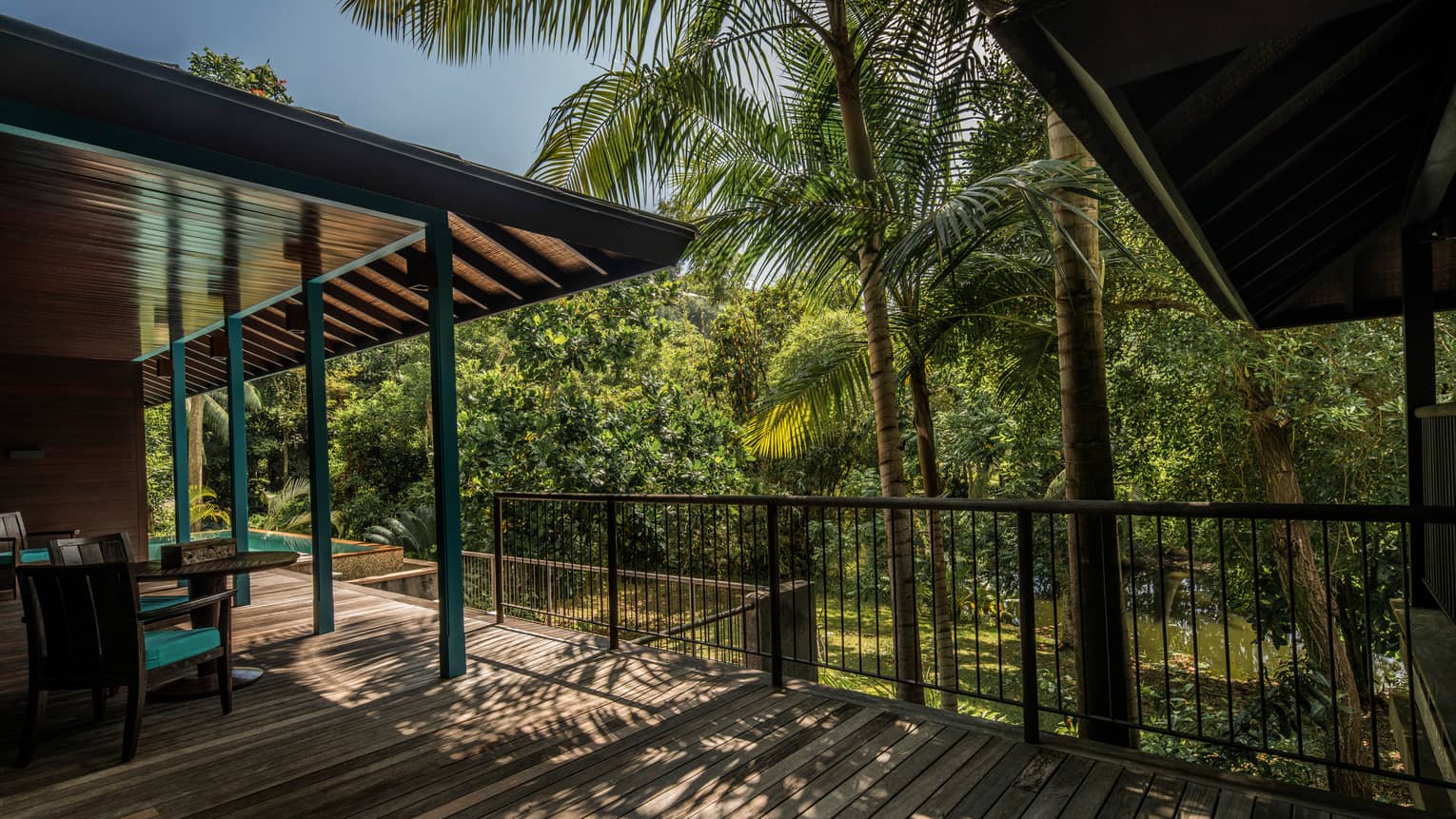 Palm trees cast shadows over Garden Villa wood deck, roof