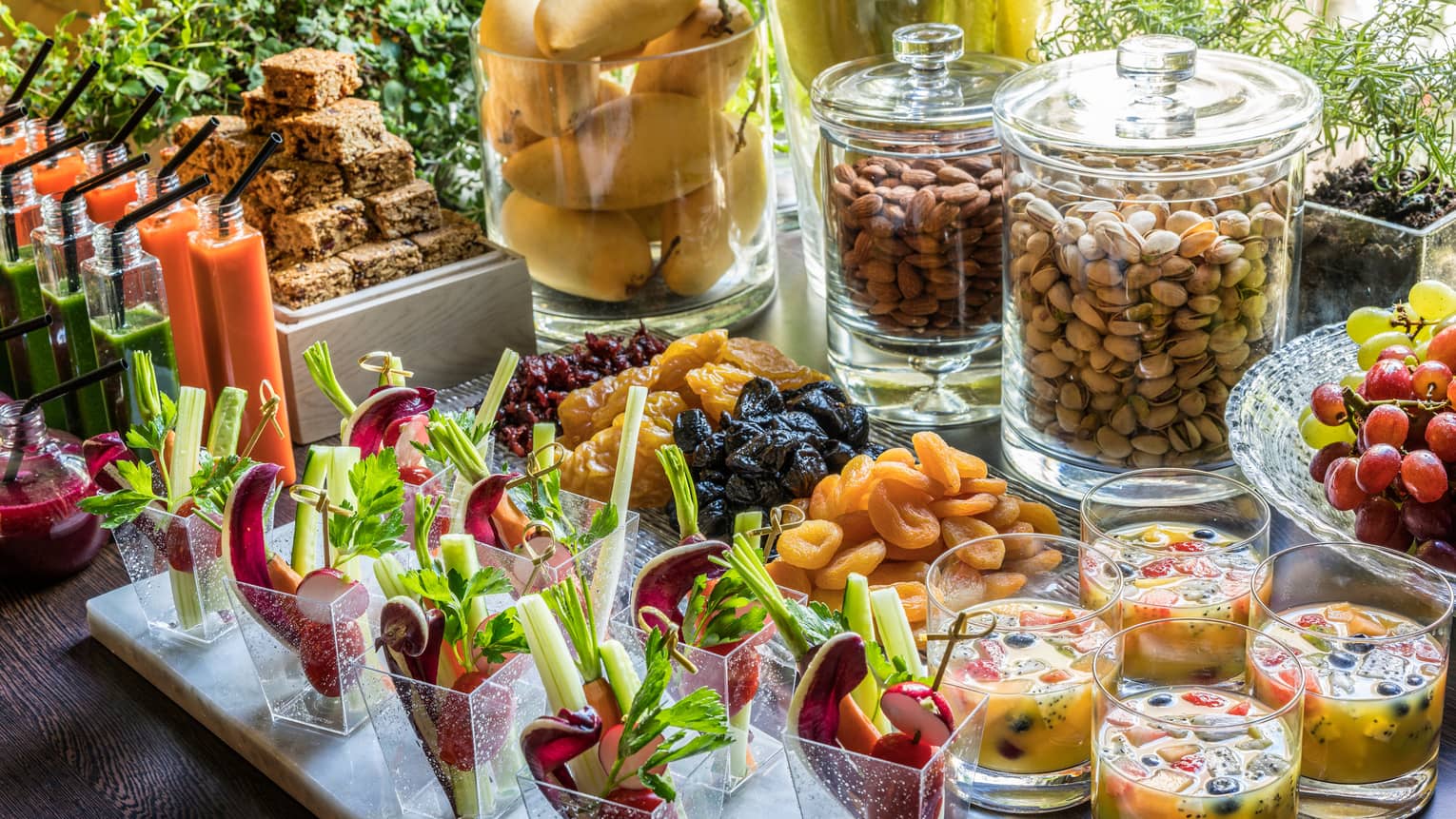 A buffet spread for a coffee break, complete with nuts, fruit, crudités and sweets