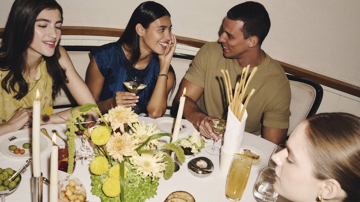 A group of people gather around a restaurant dining table