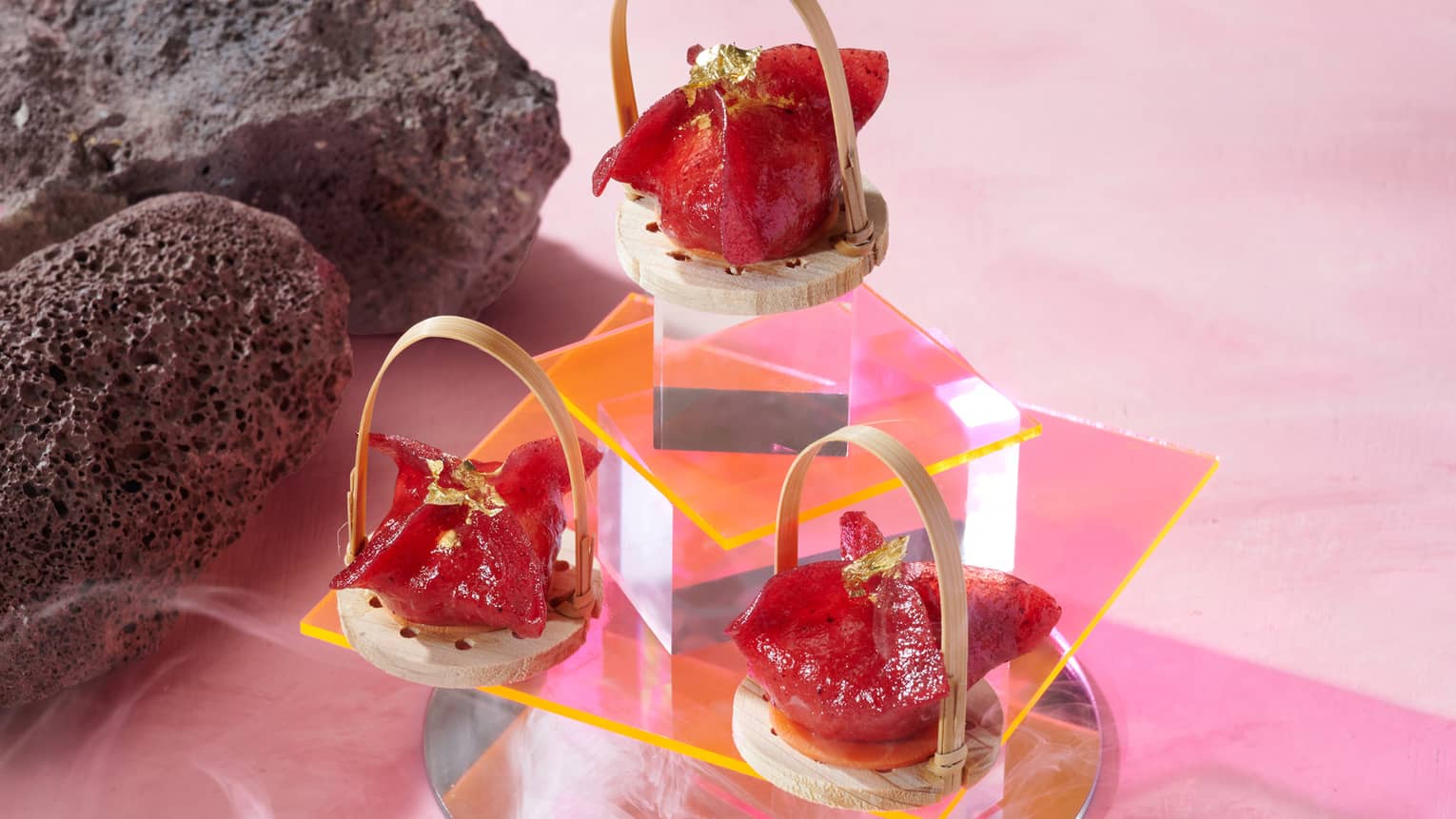 Tiered glass display of small red-hued dumplings