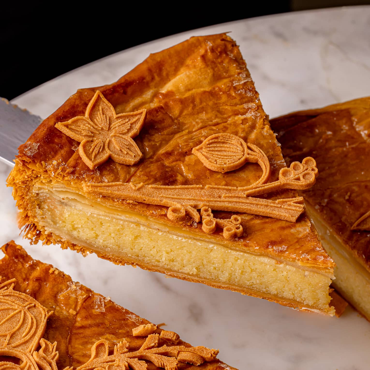 A slice of a flaky pastry with floral details