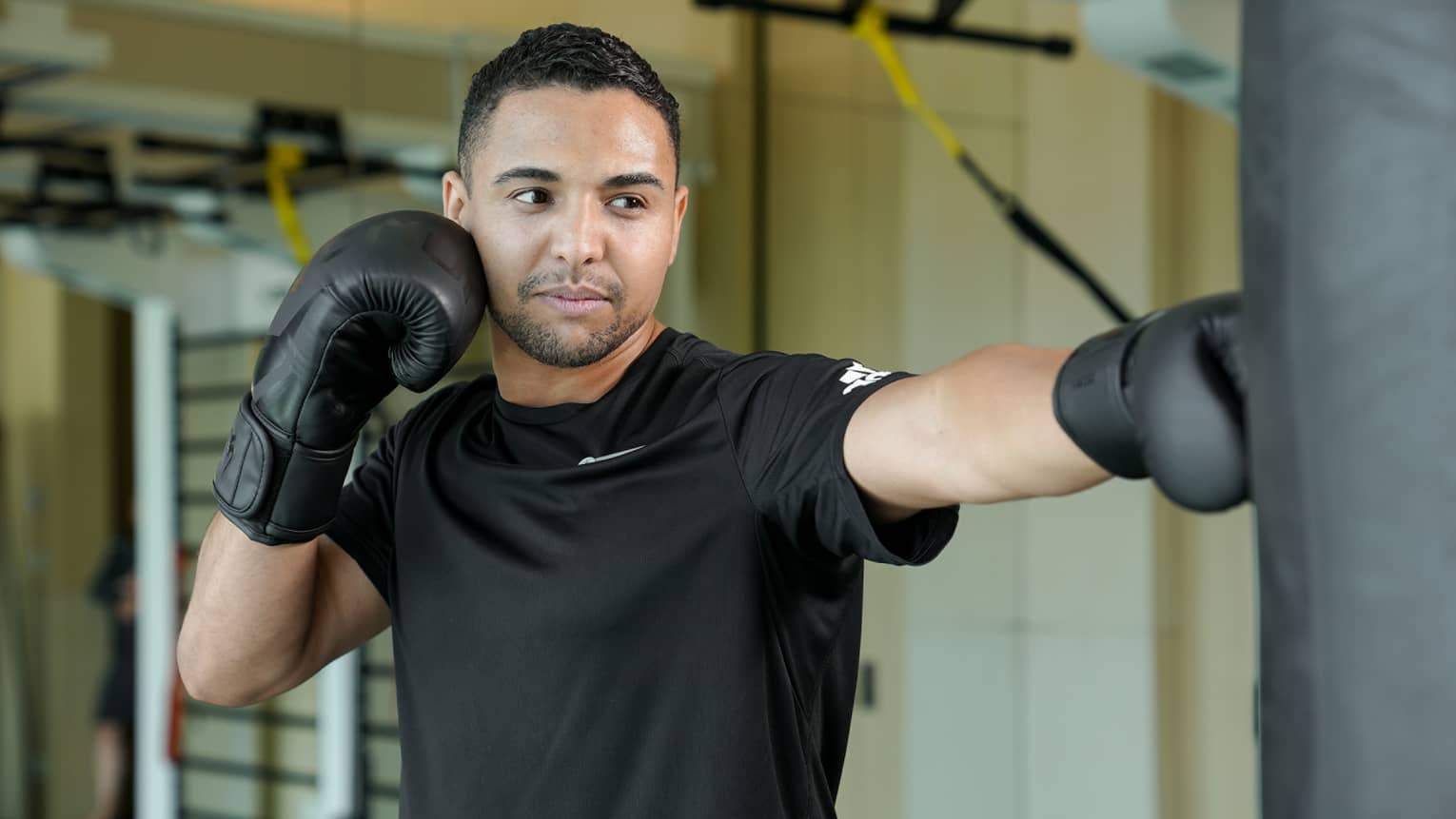 A man in boxing gloves practicing his form.