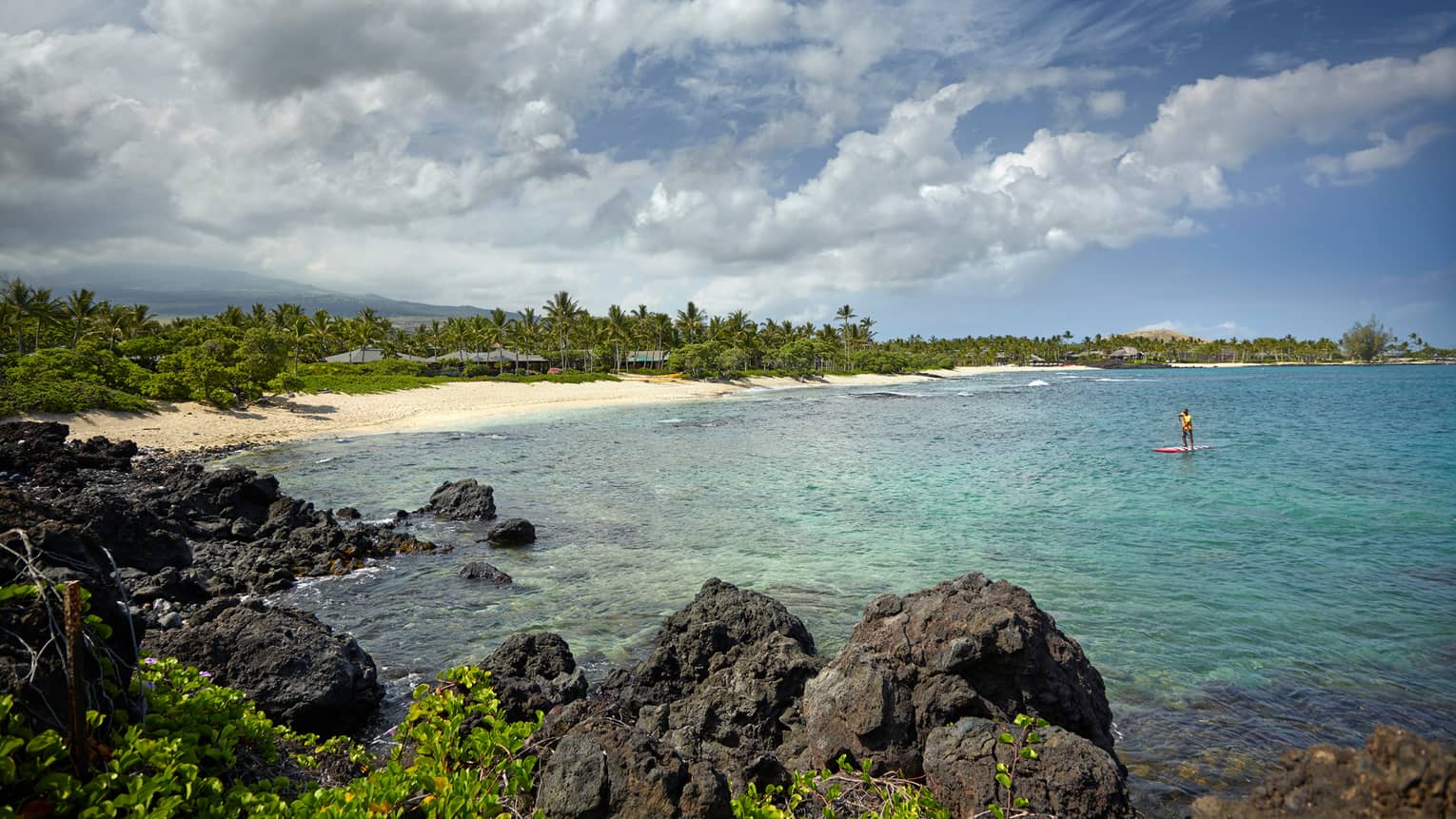Hualalai Luxury Hotel Island Kona Four Seasons Resort Person On Stand Up Paddleboard In Lagoon Past Large Black Lava Rocks Near White