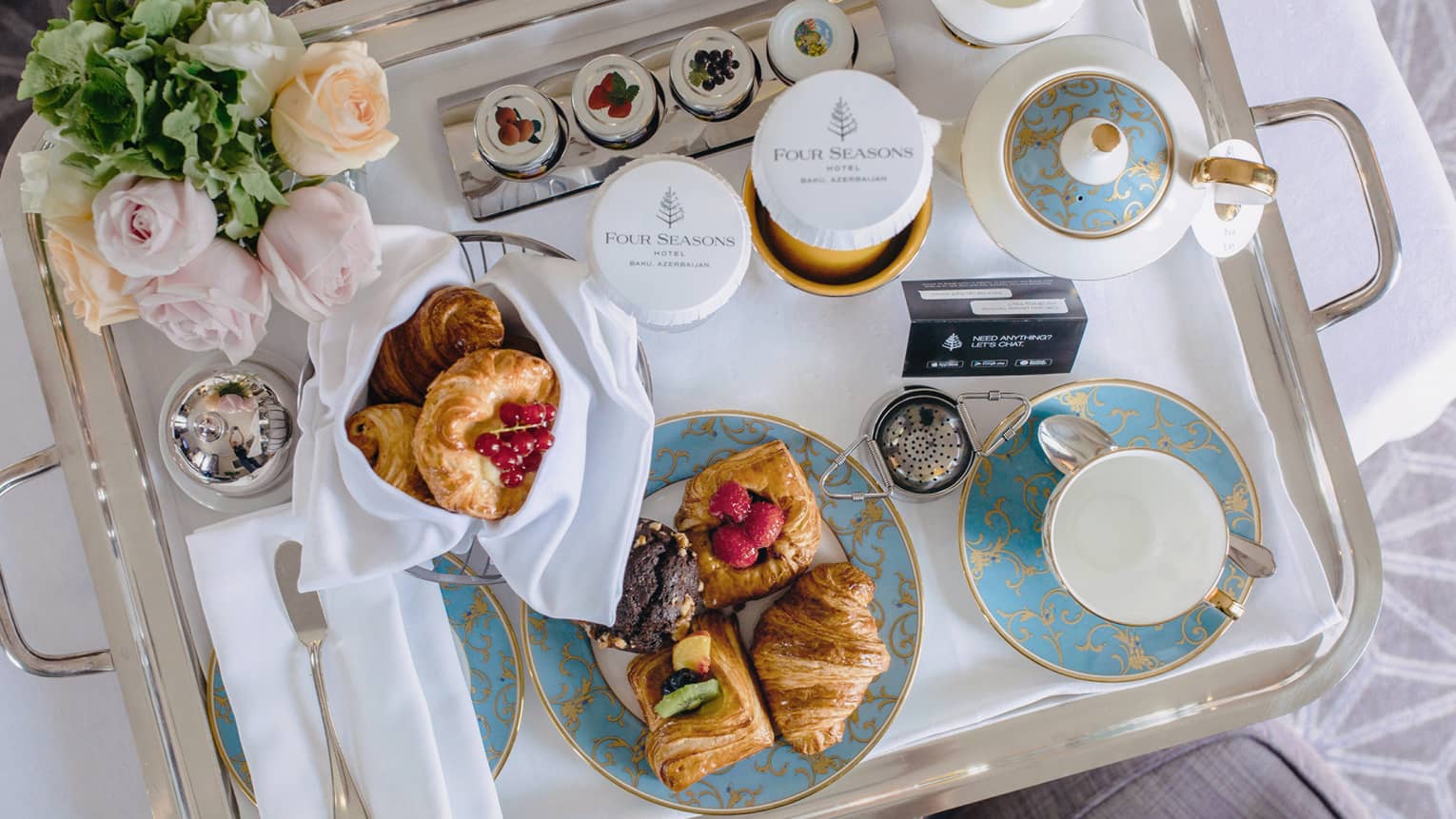 In-room dining breakfast tray with tea, pastries, roses