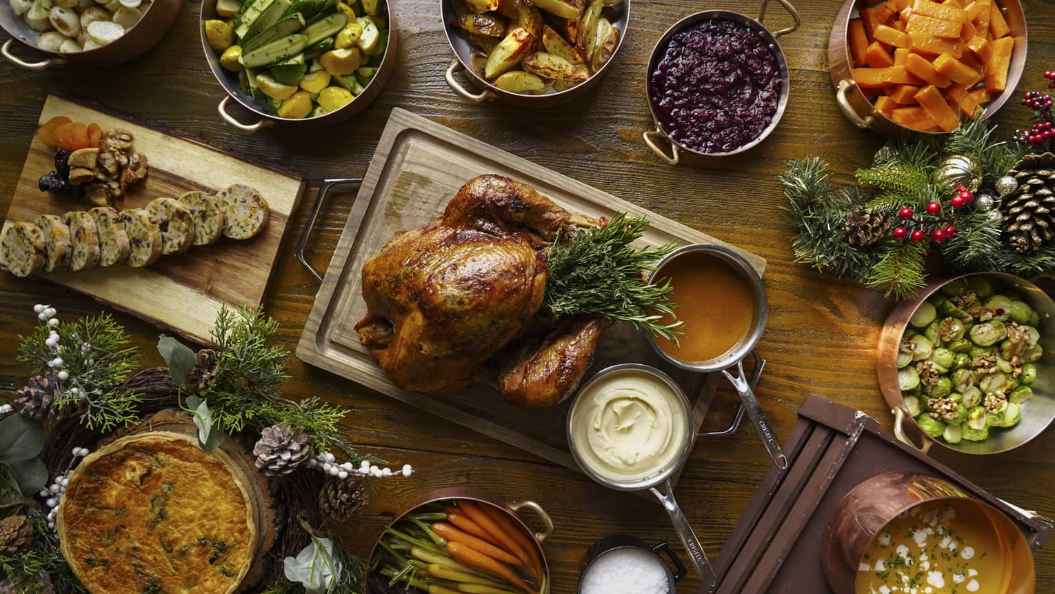 A full festive feast with a Turkey in the centre, and several copper pots of stewed vegetables surrounding