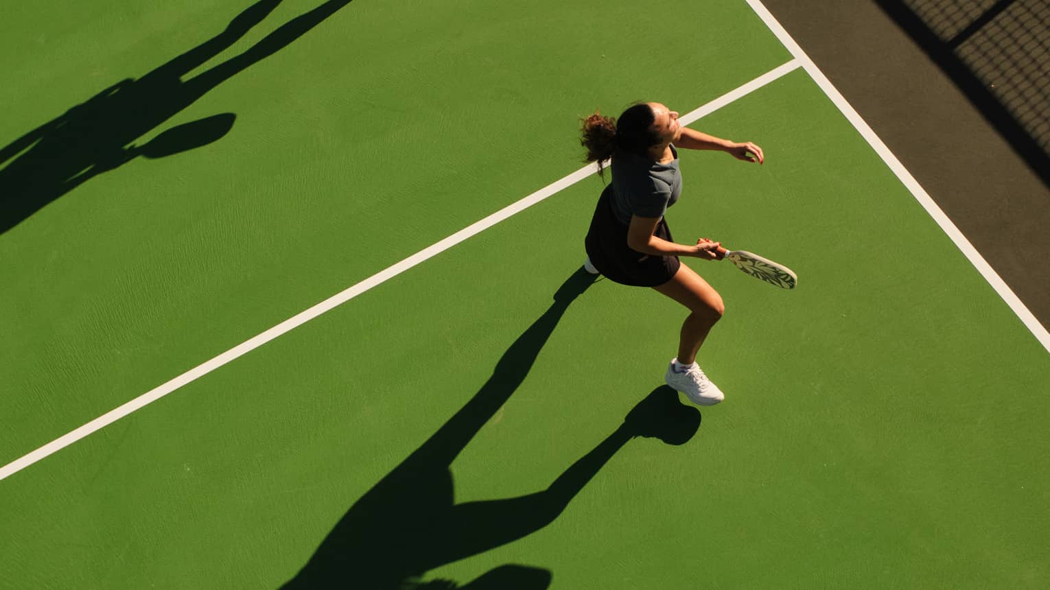 Aerial view of a man and woman playing pickleball on an outdoor court