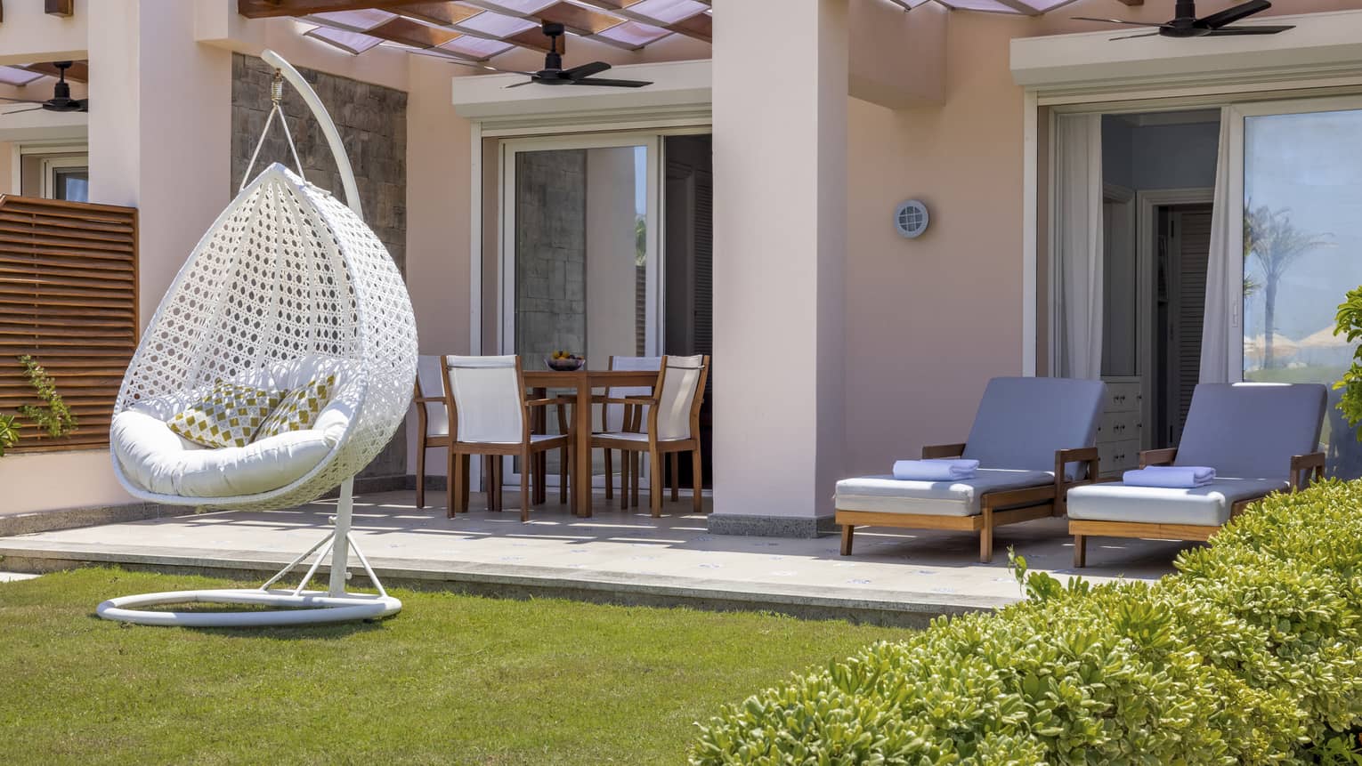Beach Deluxe Two-Bedroom Suite terrace and yard with lounge chairs, dining table and egg chair on grass