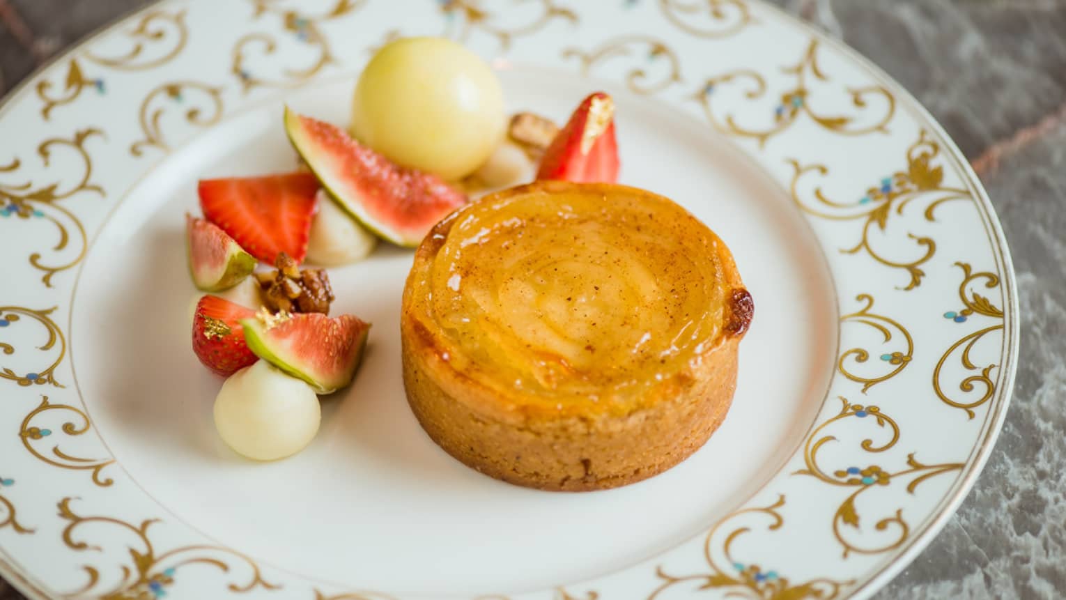 A tart covered with honey, and served with sliced fruit.