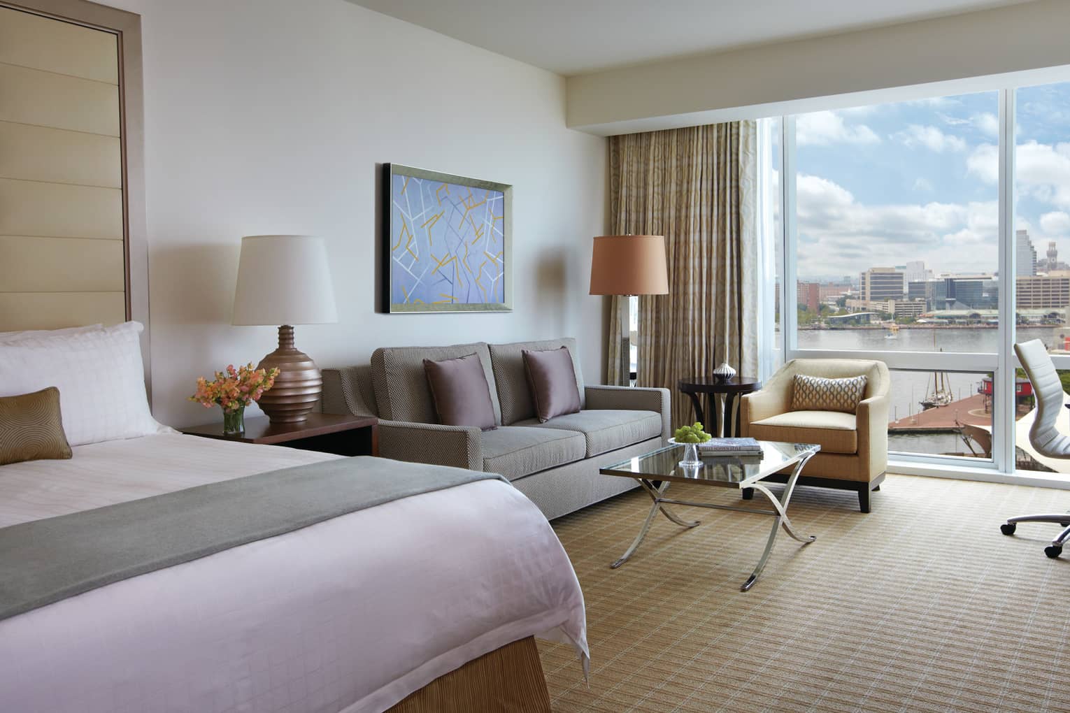 Harbour View hotel room end of bed with sash, loveseat chair by glass wall, balcony
