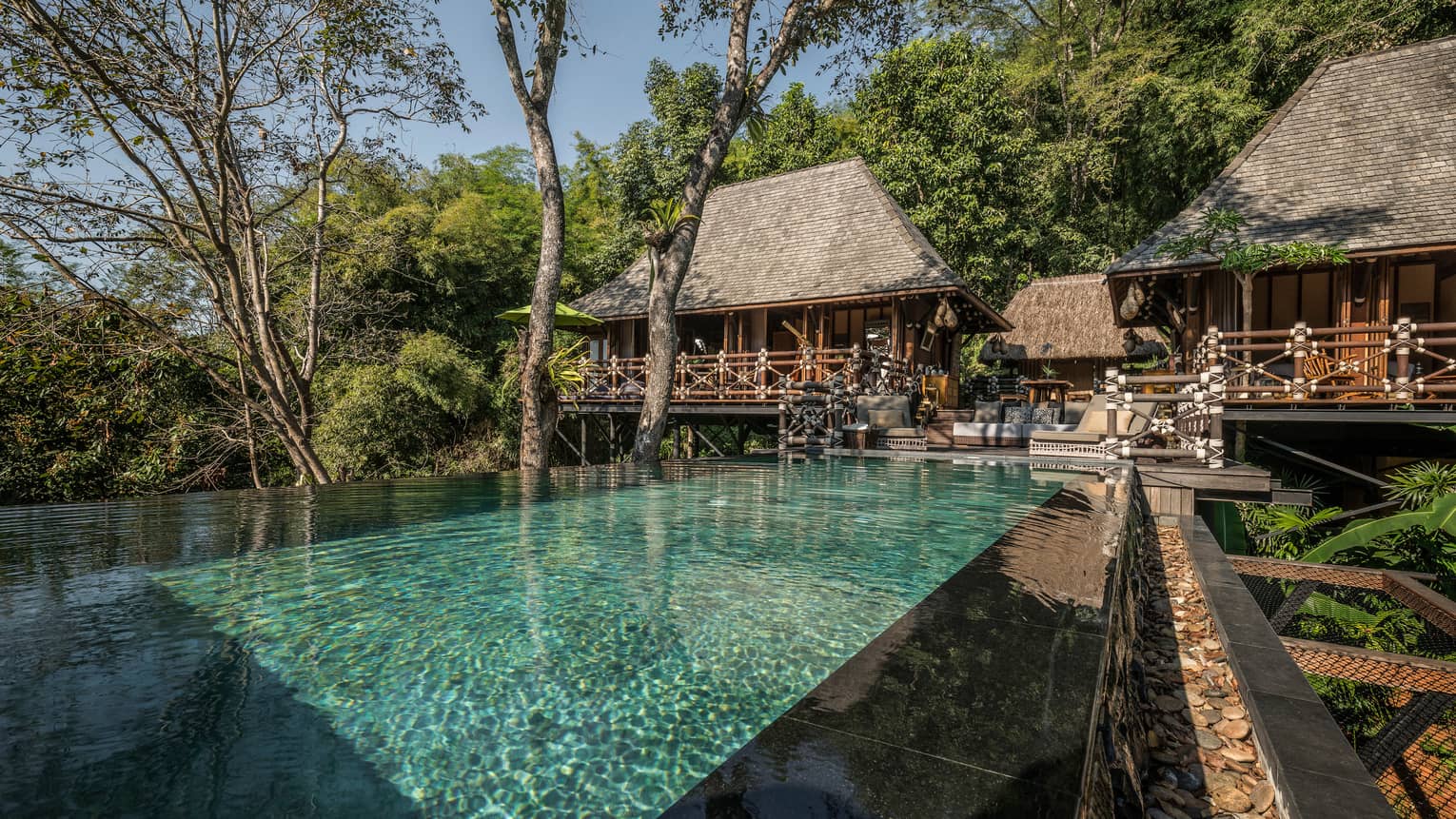 Two-bedroom Explorer's Lodge bungalows with small patio in middle leading to long swimming pool