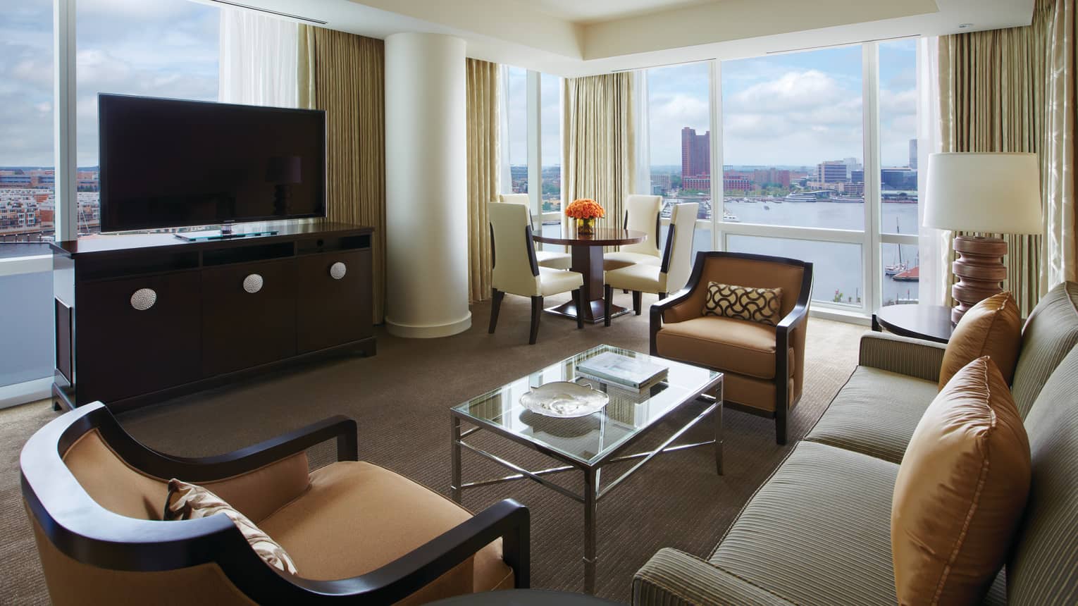 Harbour Suite loveseat, armchairs, dresser and TV in front of window overlooking water