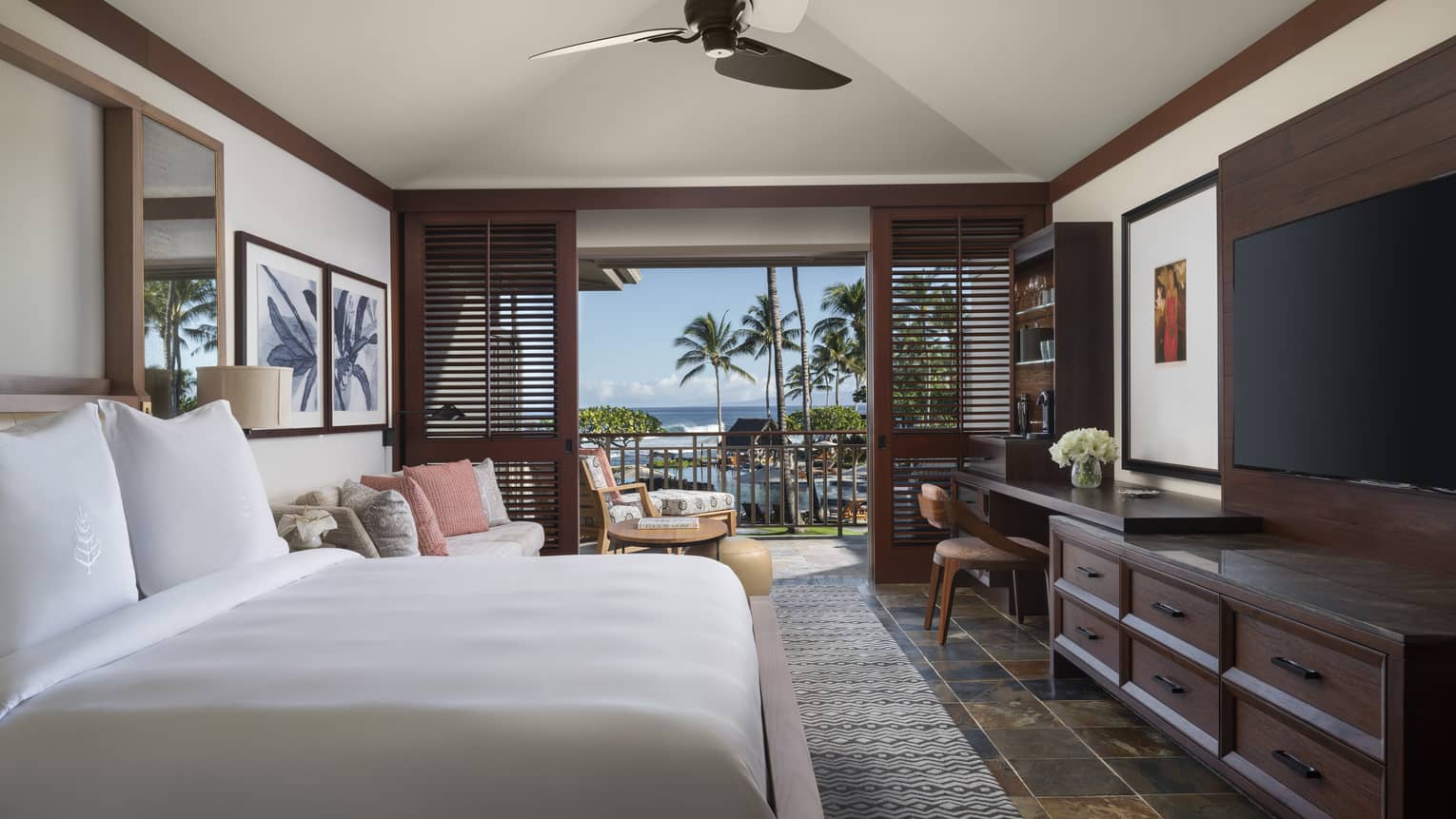 Bedroom with dark wood molding, ceiling fan, white king bed, dark dresser, walk-out terrace