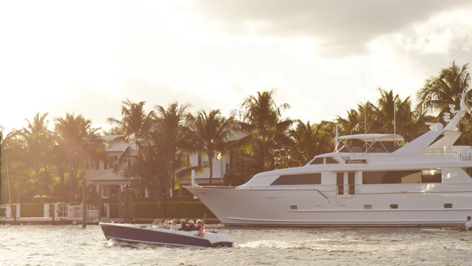 A small boat drives by bigger yacht