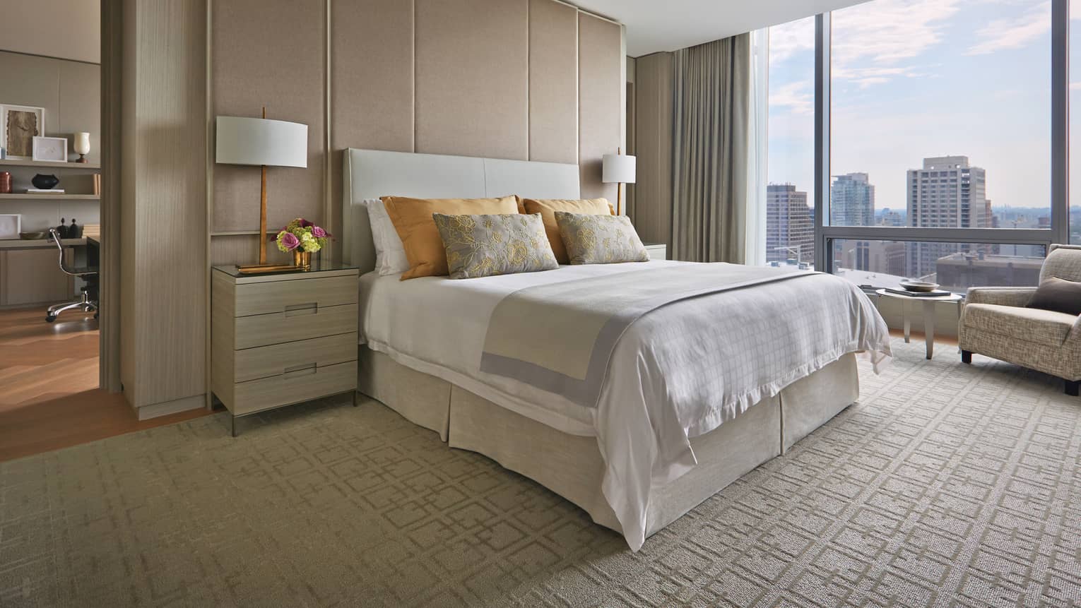 Royal Suite bed, nightstand against padded wall near floor-to-ceiling window