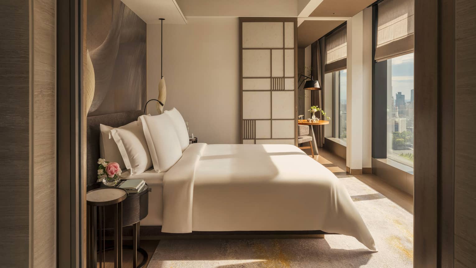 Luxury hotel room with king bed facing a wall of windows and contemporary Japanese design