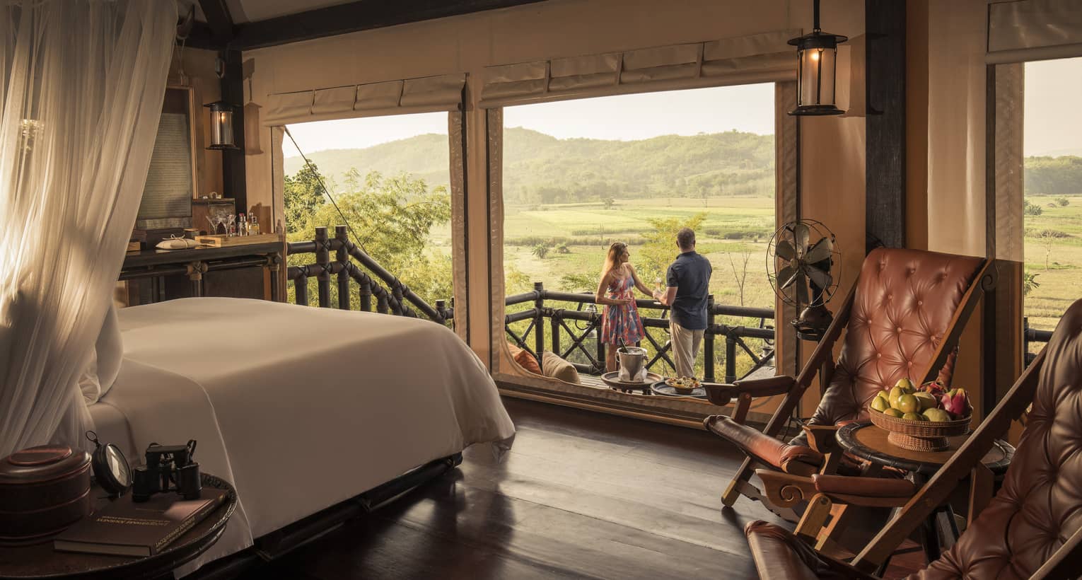 Couple enjoys cocktails overlooking fields and mountains