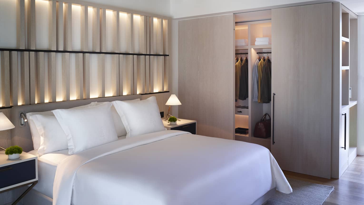 Bungalow Sea View with white king bed, backlit wall, closet with sliding wooden doors, exposed rafter ceiling, ceiling fan