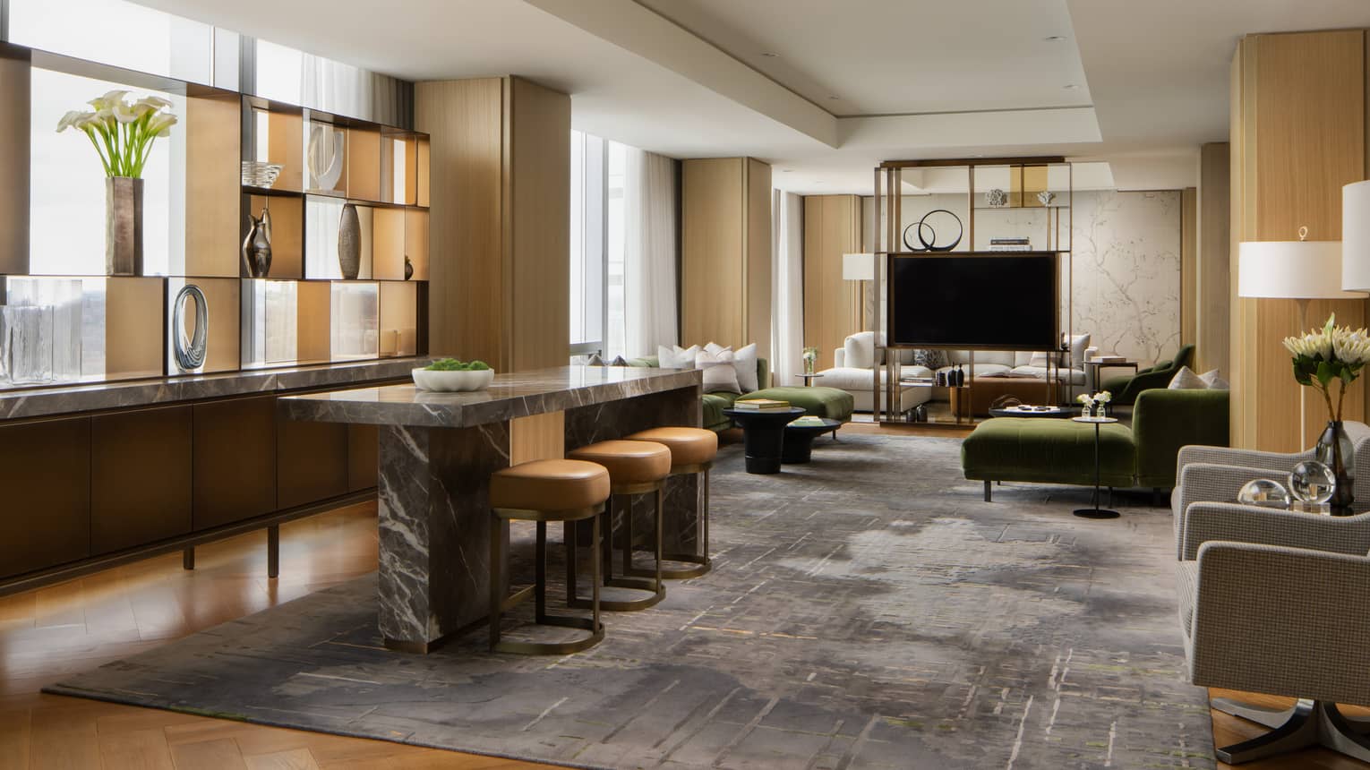 Royal suite living area with an open layout featuring a marble-top counter, a large TV, elegant décor and comfortable seating