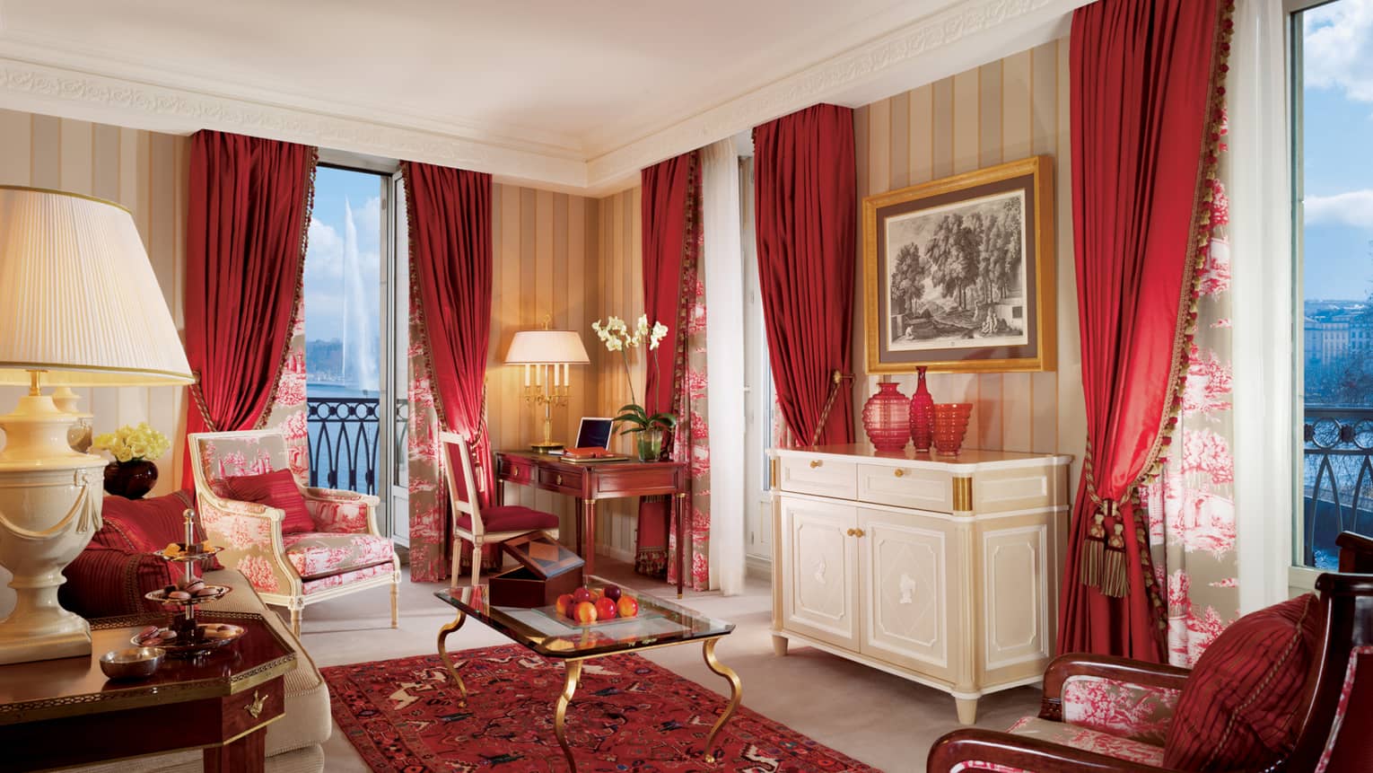 Suite Mont Blanc with dark red curtains, accent chair and rug, glass coffee table, French balcony at dusk