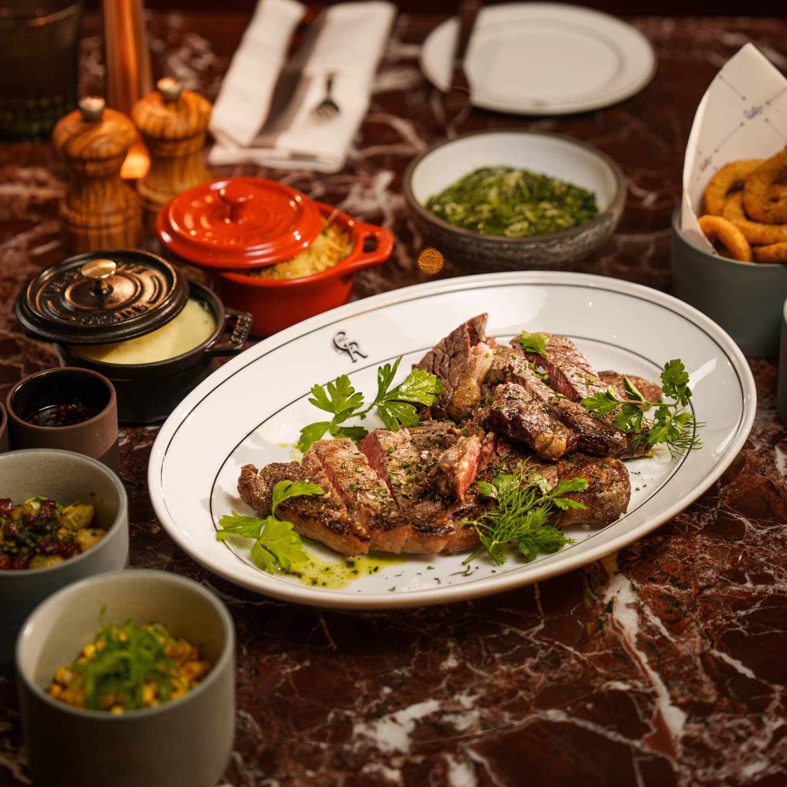Burgundy marble dining table filled with a variety of plates and small bowls