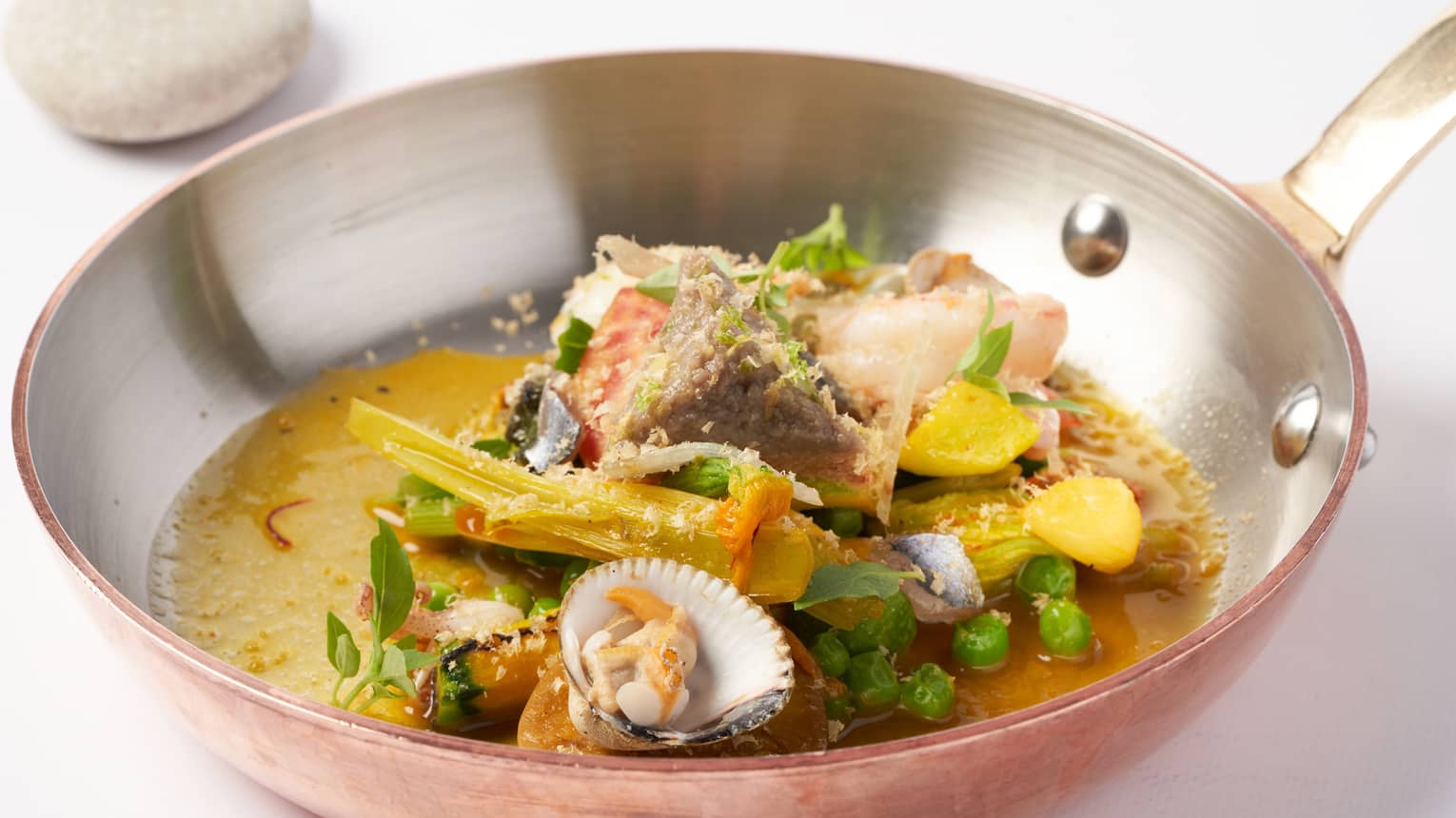Pan-roasted Mediterranean seafood soup with clams, anchovies and vegetables from the hinterland