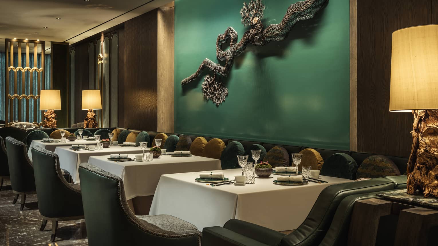 Yu Yuan dining tables, chairs under green wall with modern wire sculpture