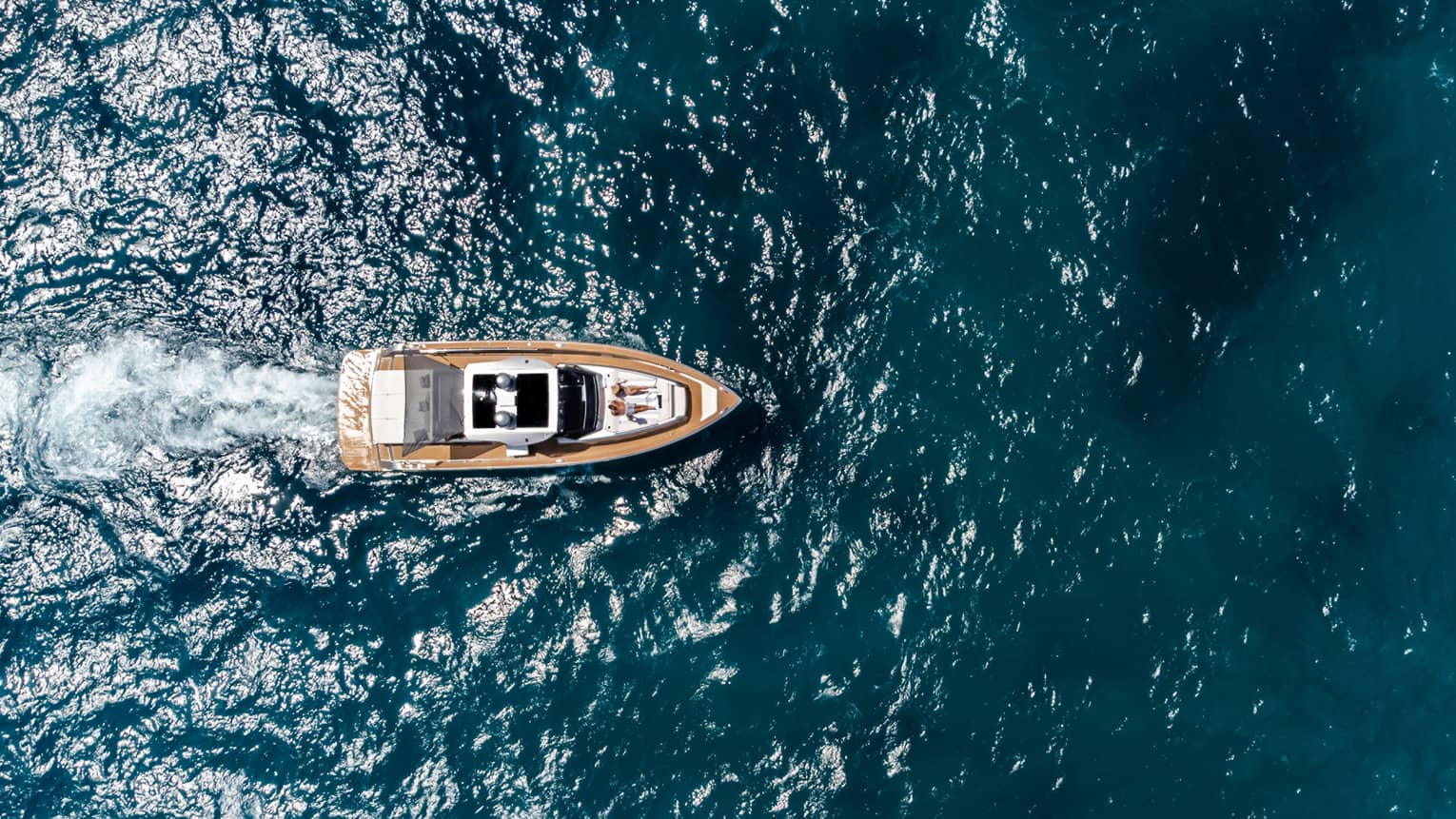Aerial view of a couple lounging on a yacht in the ocean