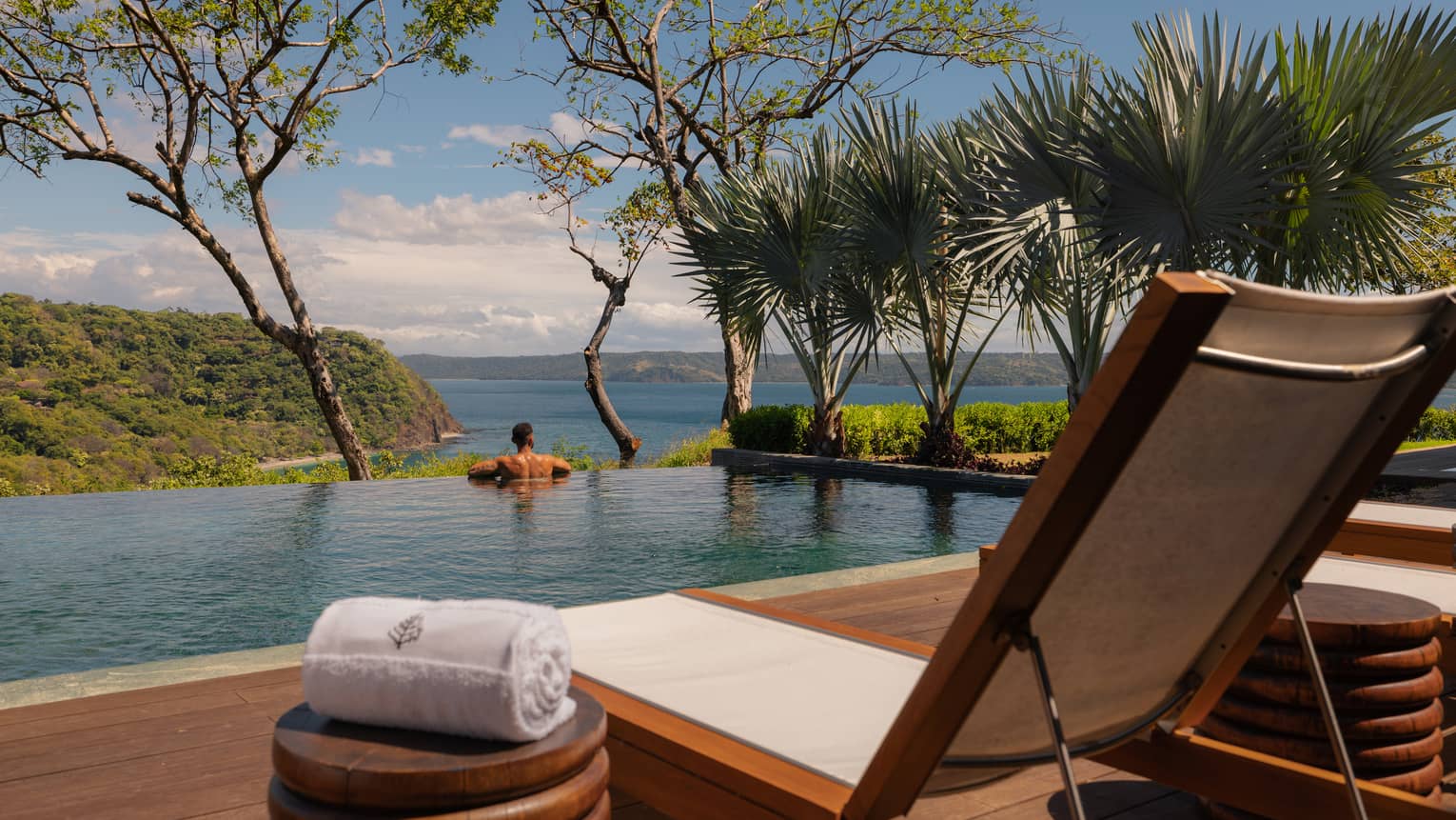 Person relaxes in private infinity-edge pool overlooking the ocean
