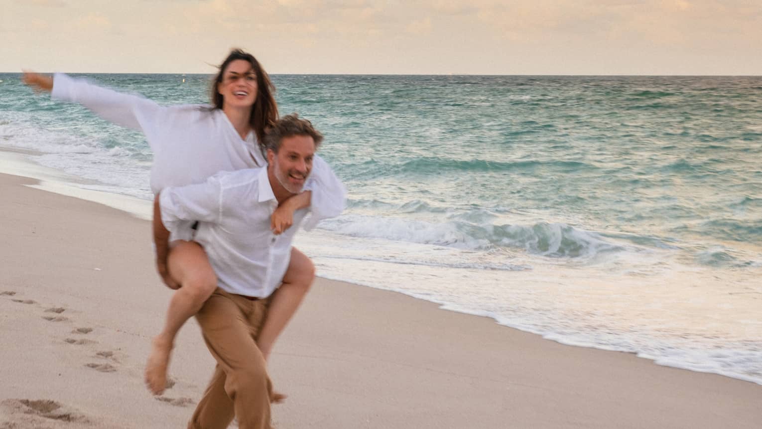 Two guests taking a walk on the beach near the ocean