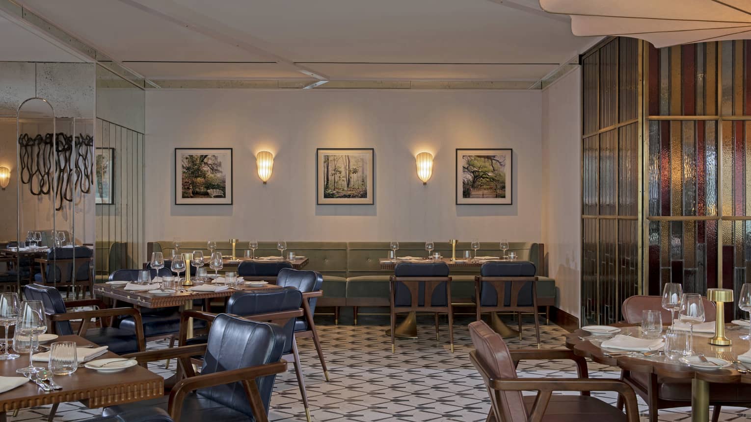 Dining room of restaurant, with booths and leather chairs, tiled floor