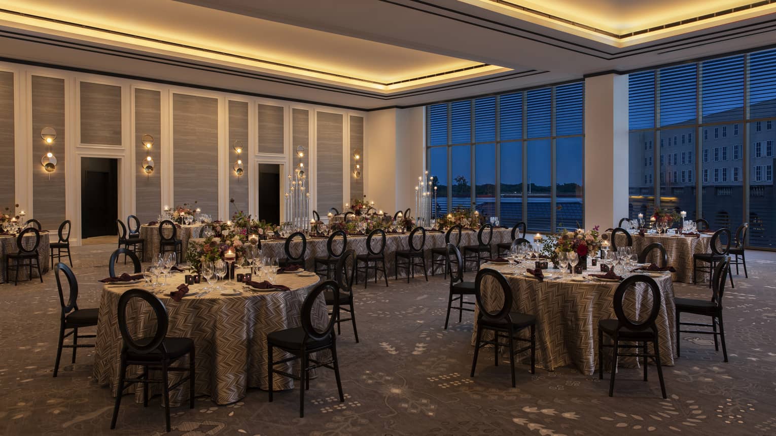 Dimly-lit ballroom with four round tables and one long rectangular table
