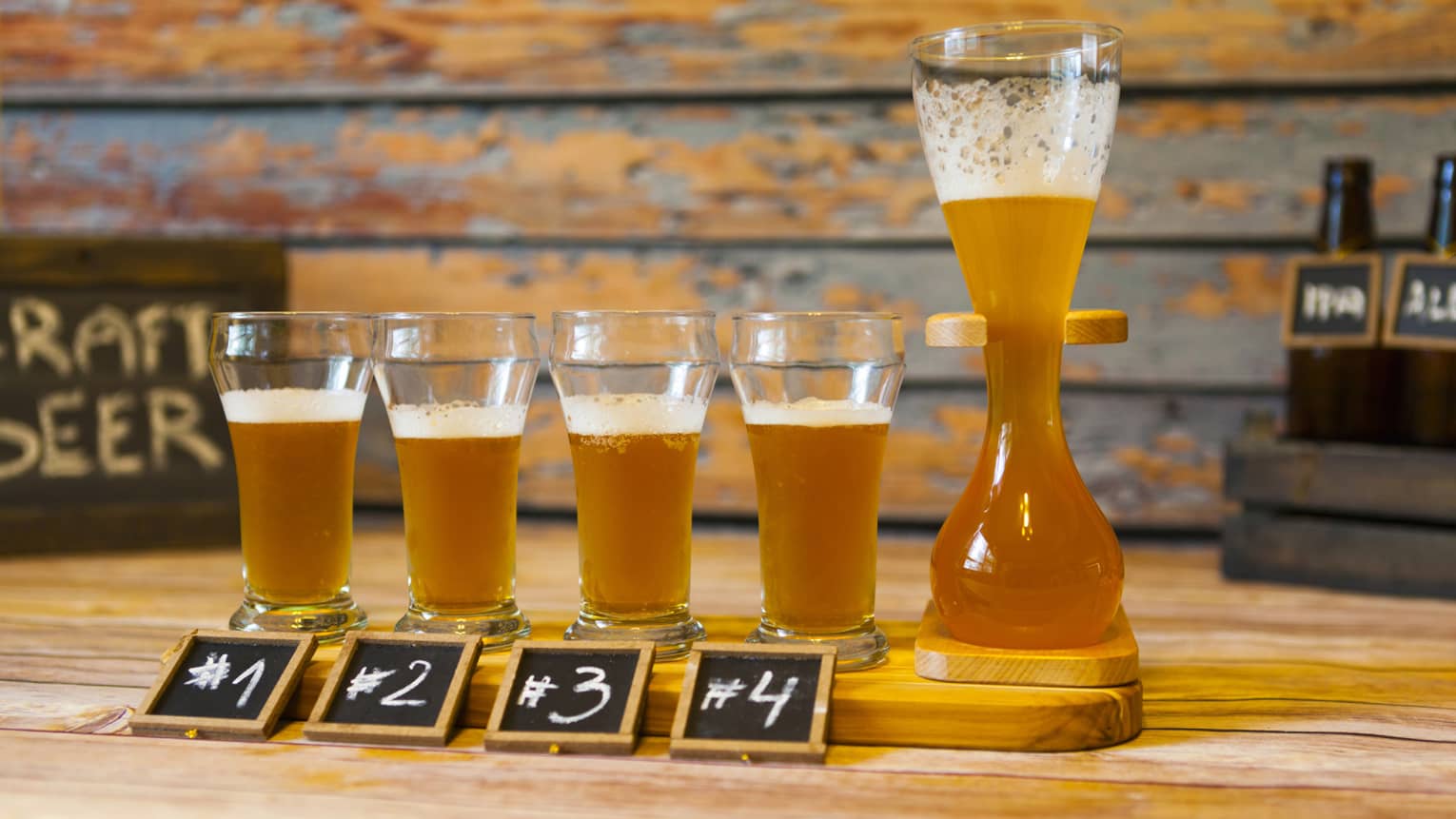 Flight of craft beer with numbers one through four on small chalk boards