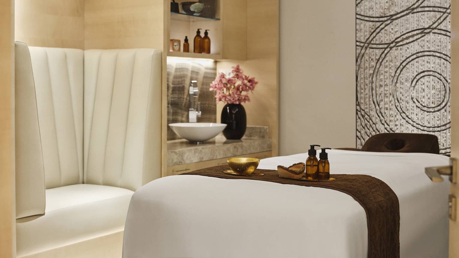 Spa treatment room with spa table against shiny wall art