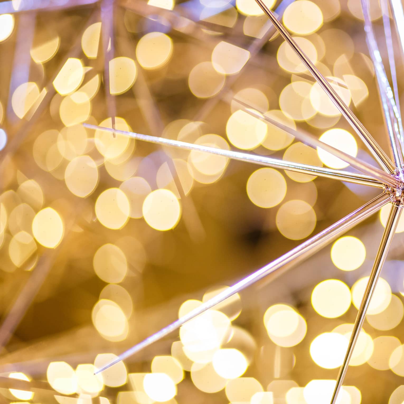 A pointy gold ornament surrounded by small yellow lights.