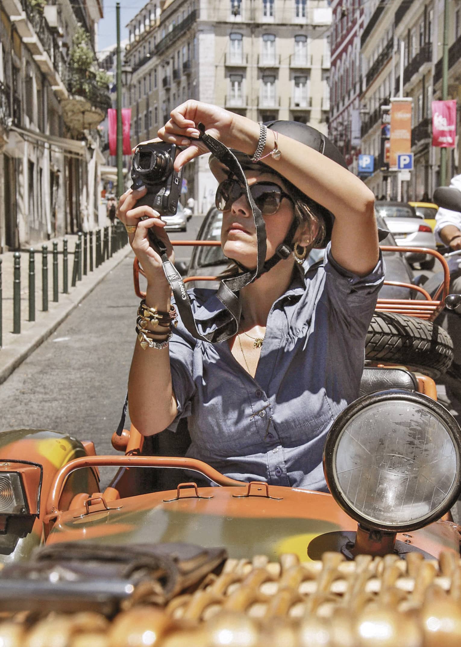 Woman sitting in Moto Side Car takes photos of streets