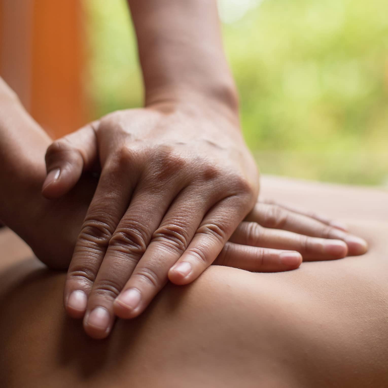 Close up of hands massaging a back