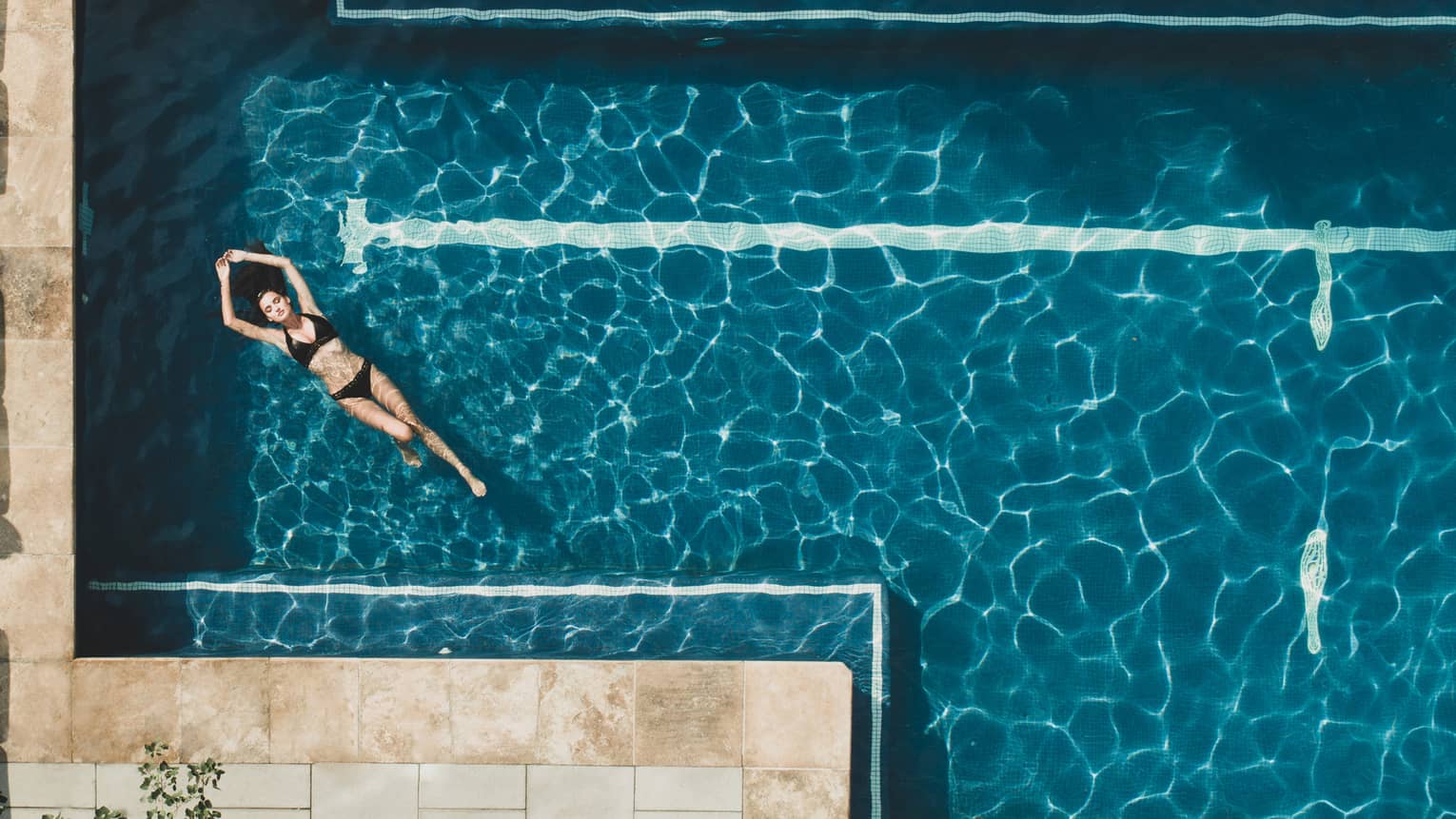 Woman floating on her back in the pool water.