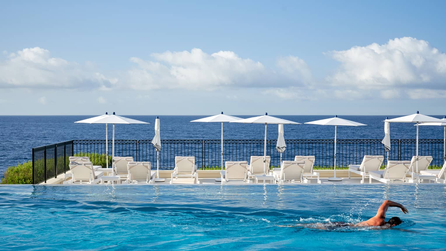 Man swimming in infinity pool