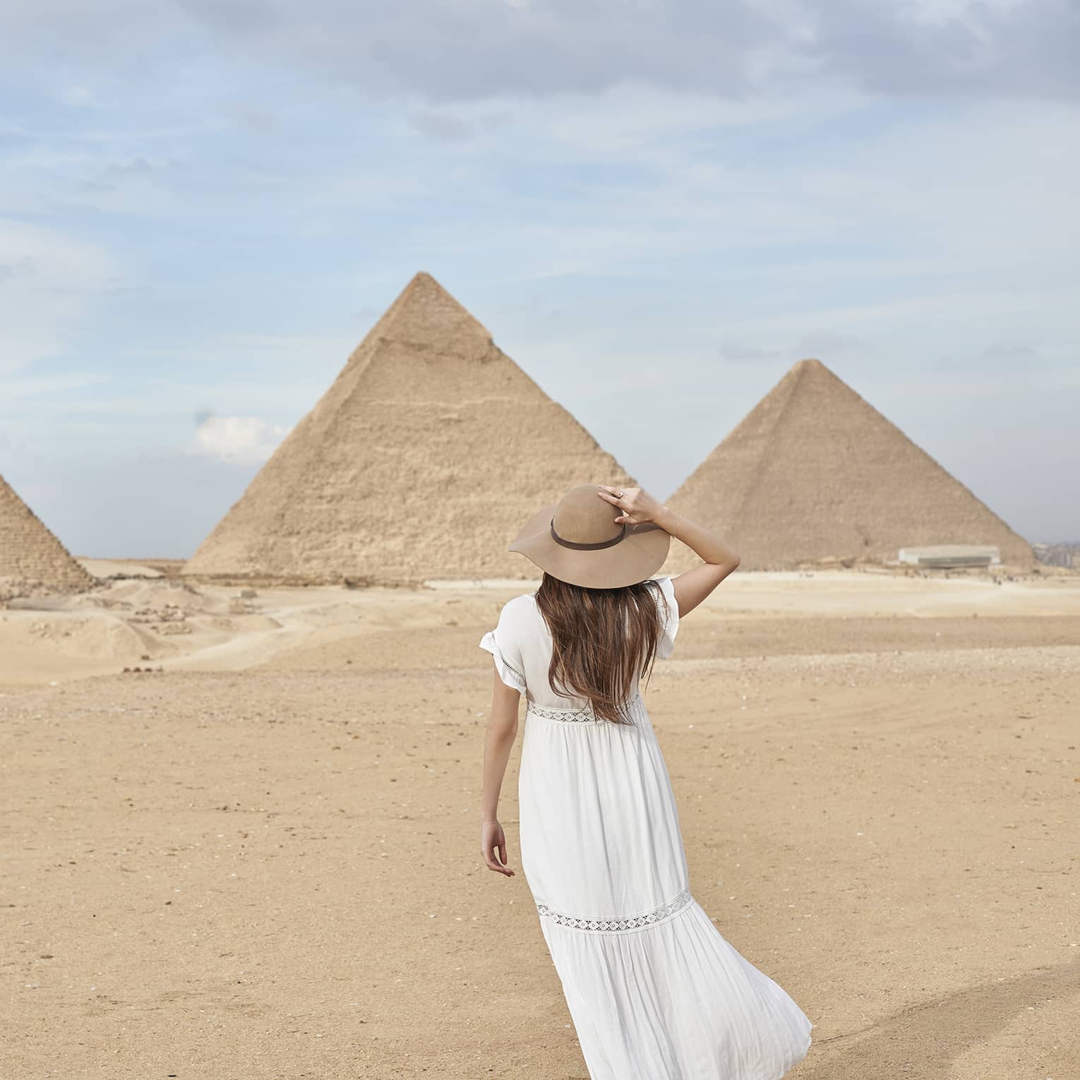 A guest wearing a linen dress observing the Great Pyramids