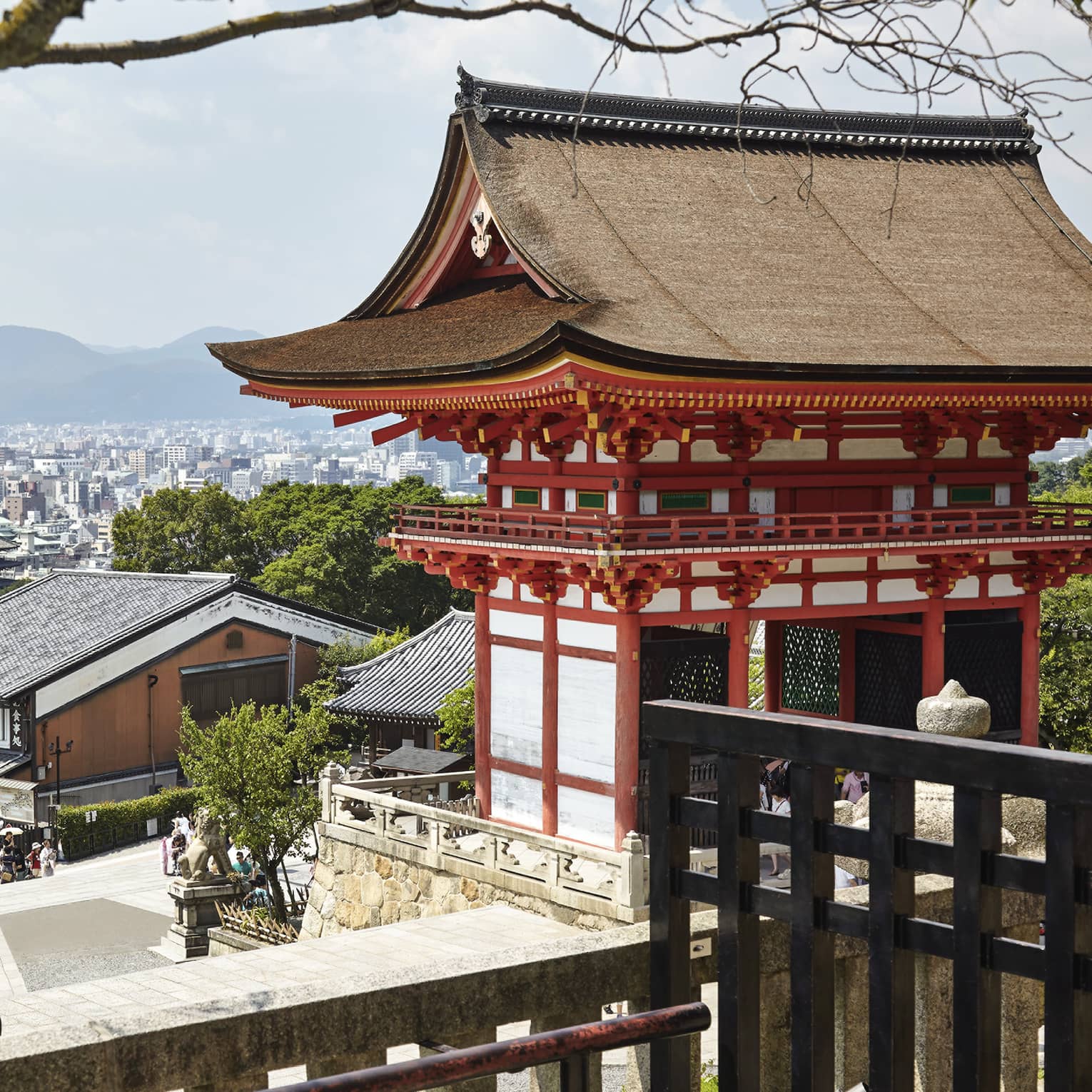 People walk along street under traditional Japanese building, Kyoto city views