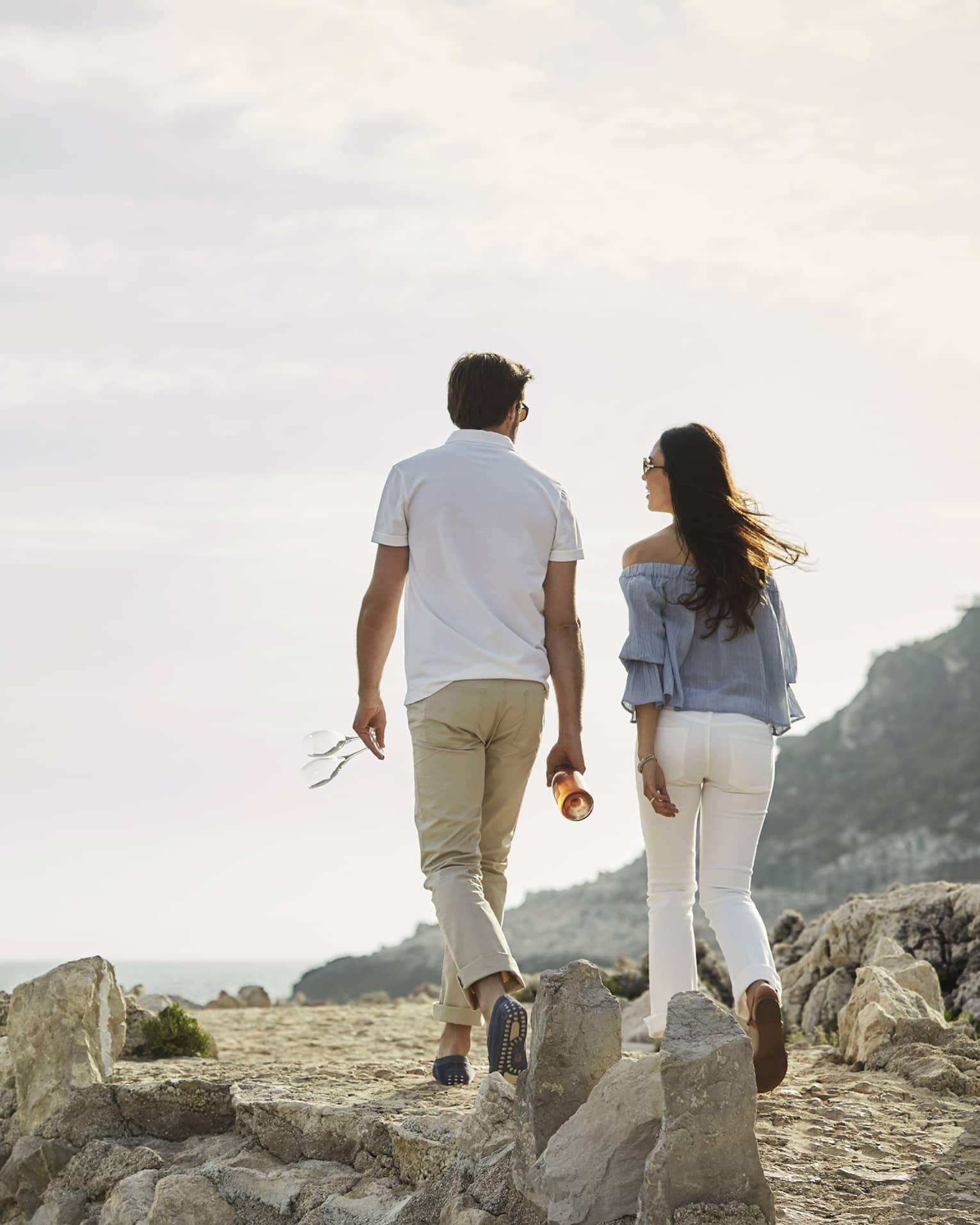 Back of couple walking across rocky trail on Saint-Jean Cap Ferrat Coastal Pathway