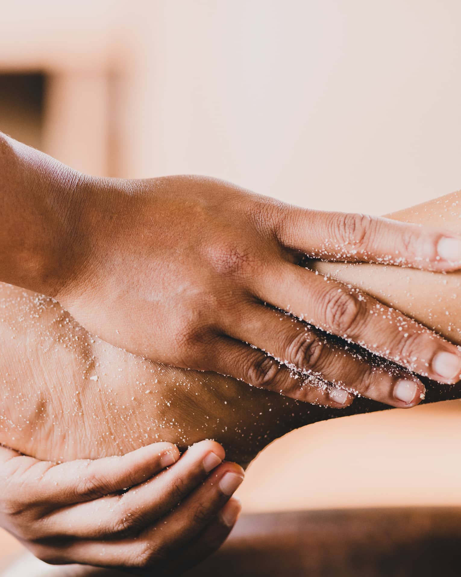 Hands hold a person's foot and ankle in a spa