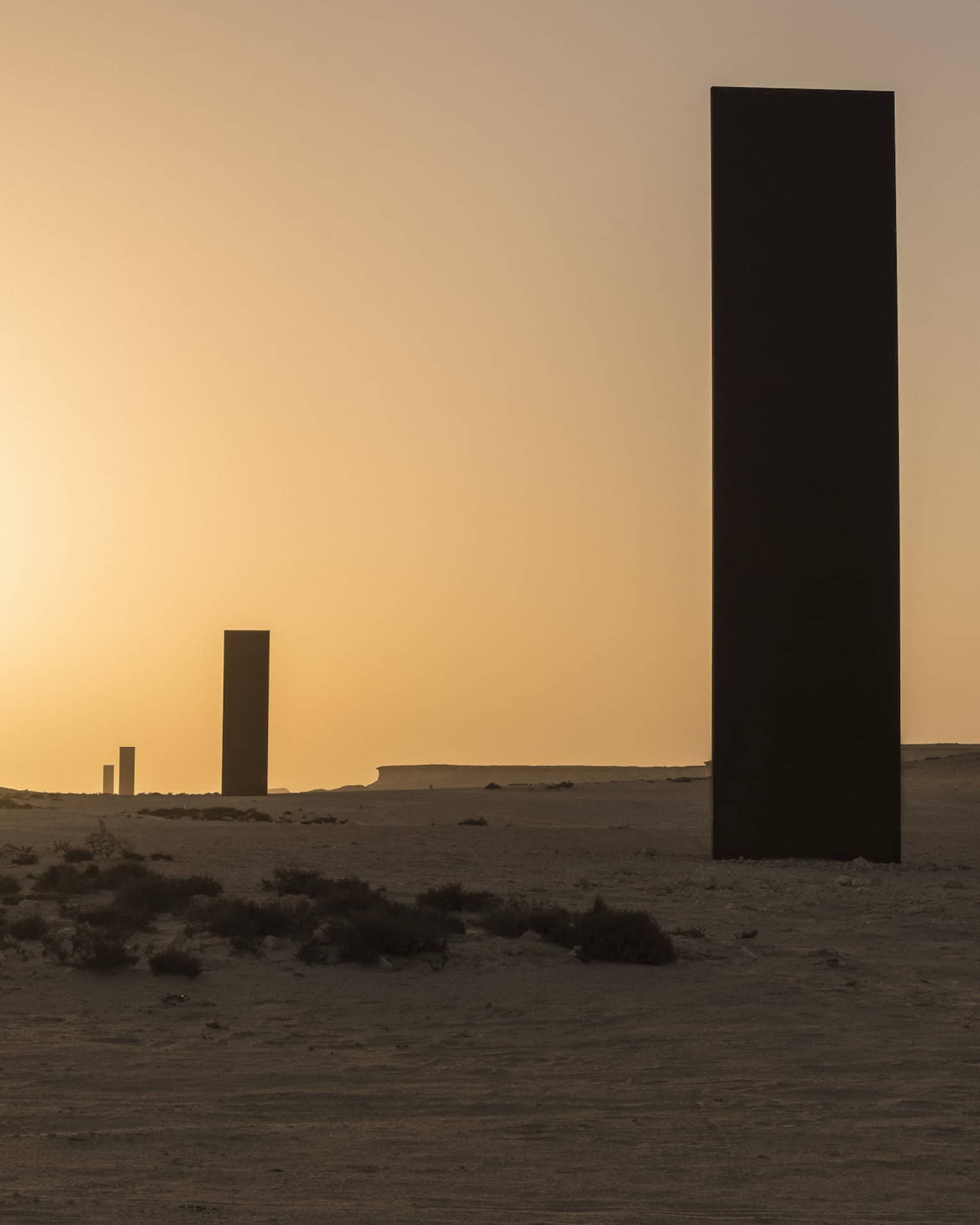 Silhouettes of Richard Serra Sculpture against sunset