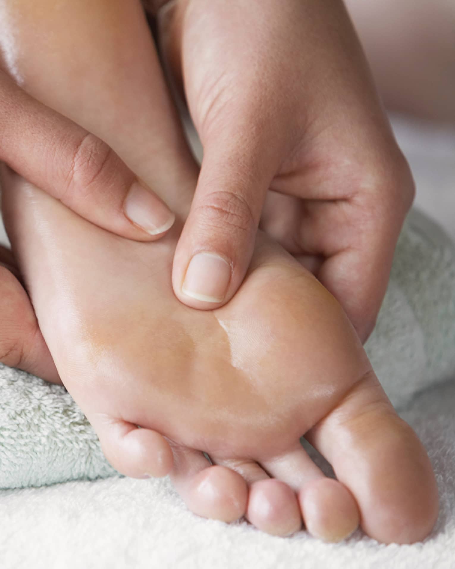 Close-up of hands massaging pressure points on feet