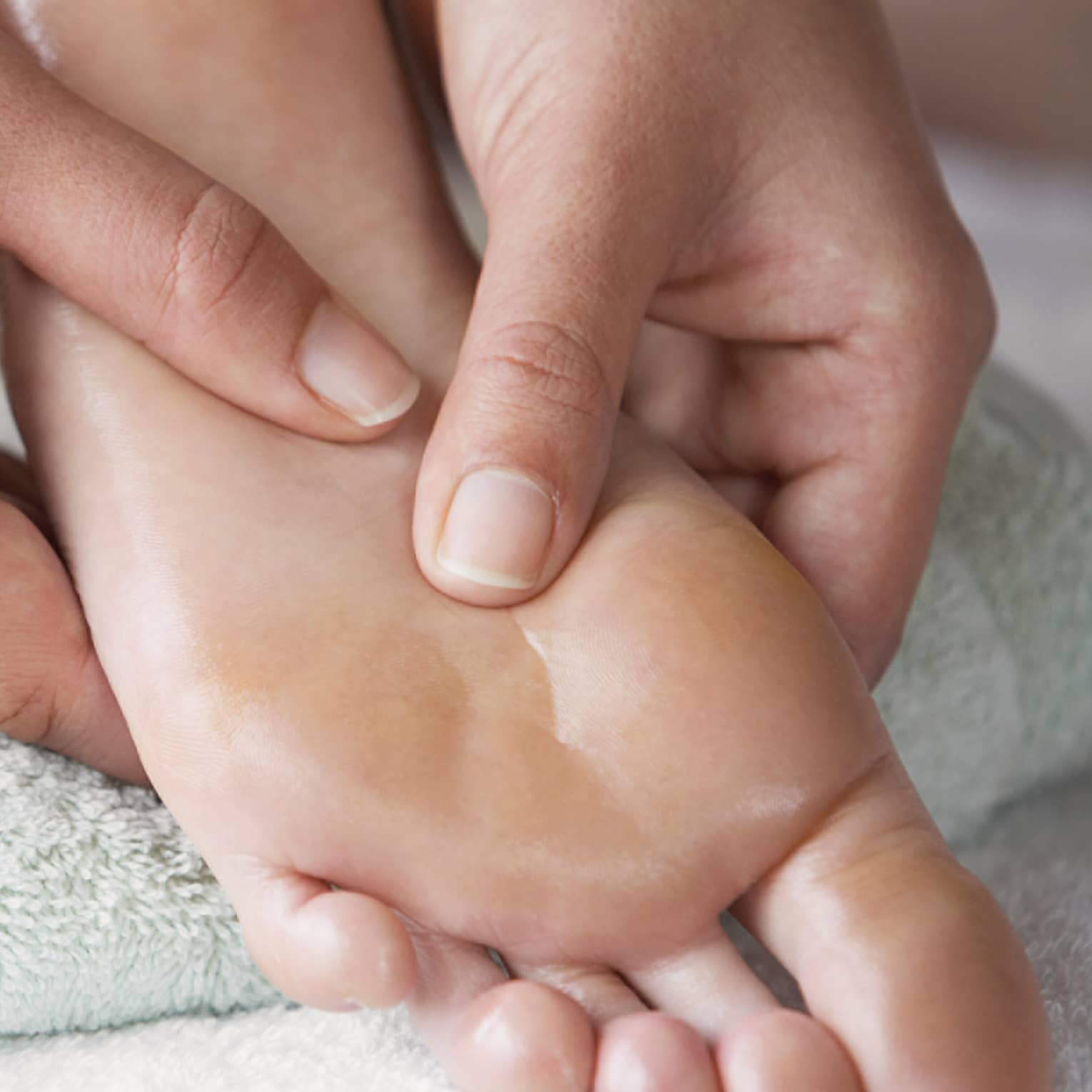 Close-up of hands massaging pressure points on feet