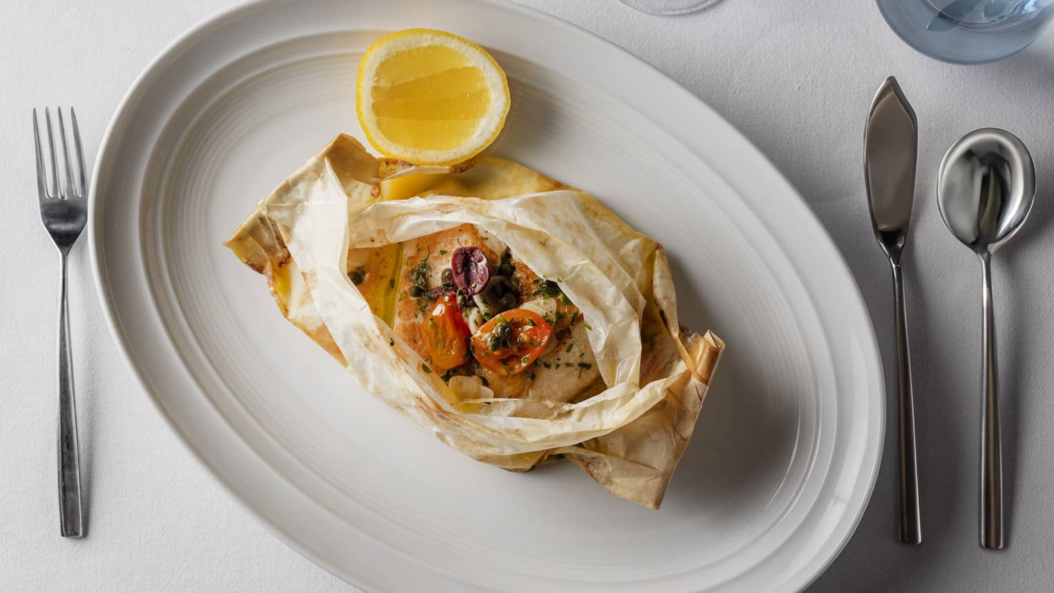Branzino al cartoccio served in traditional parchment paper